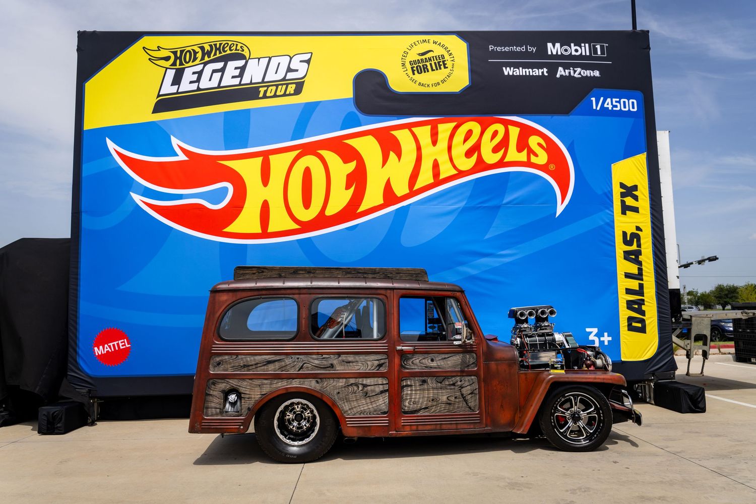 A rusty vintage woody wagon displayed as a Hot Wheels Legends Tour 1/4500 die-cast car in Dallas TX.