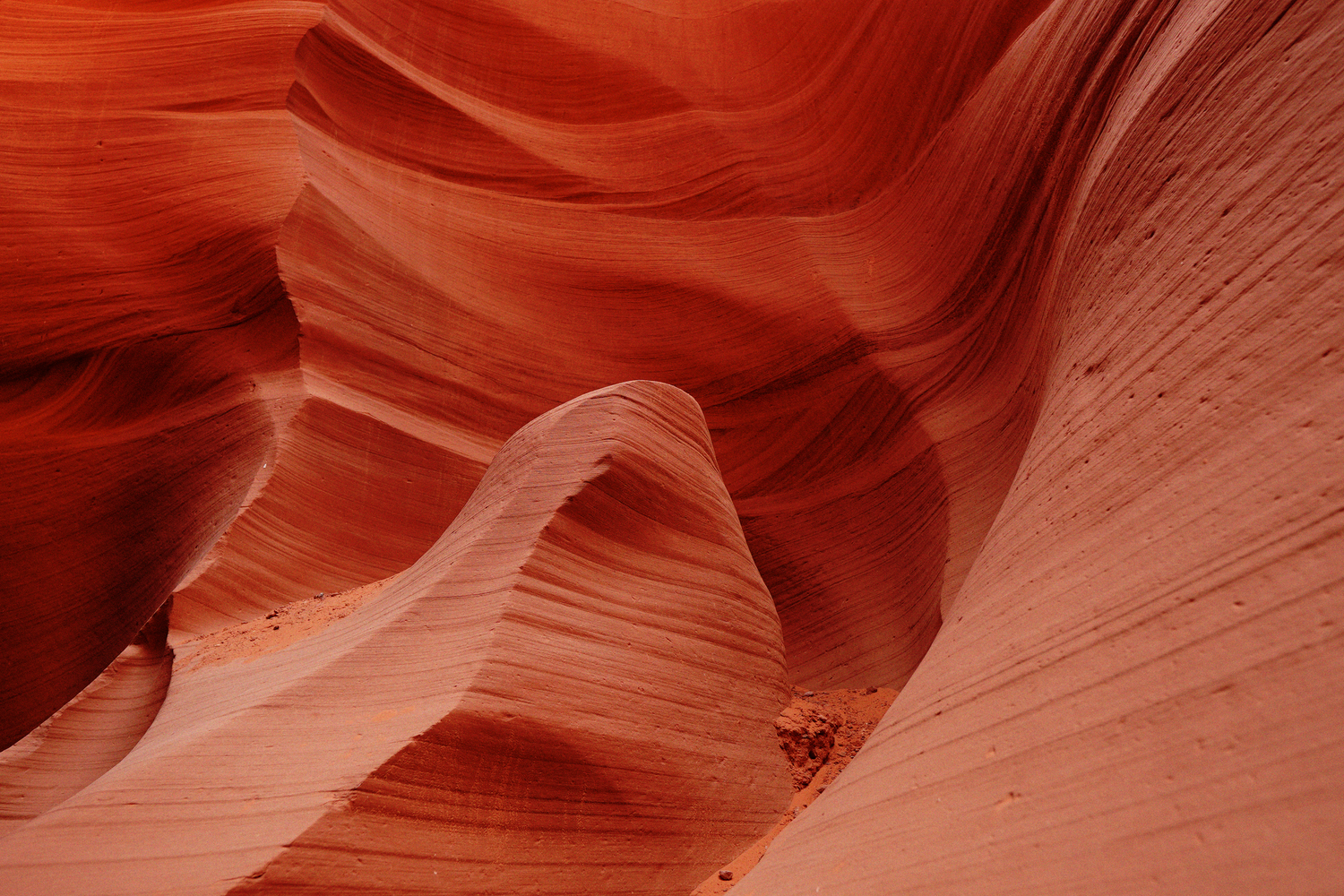 Stunning orange and red swirling sandstone walls of Antelope Canyon with smooth flowing rock formations.