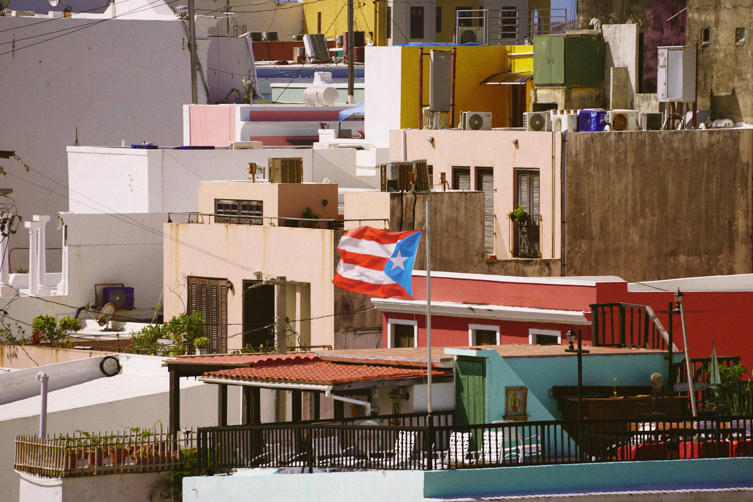 Colorful buildings with a Puerto Rico flag displayed prominently in a vibrant urban neighborhood.
