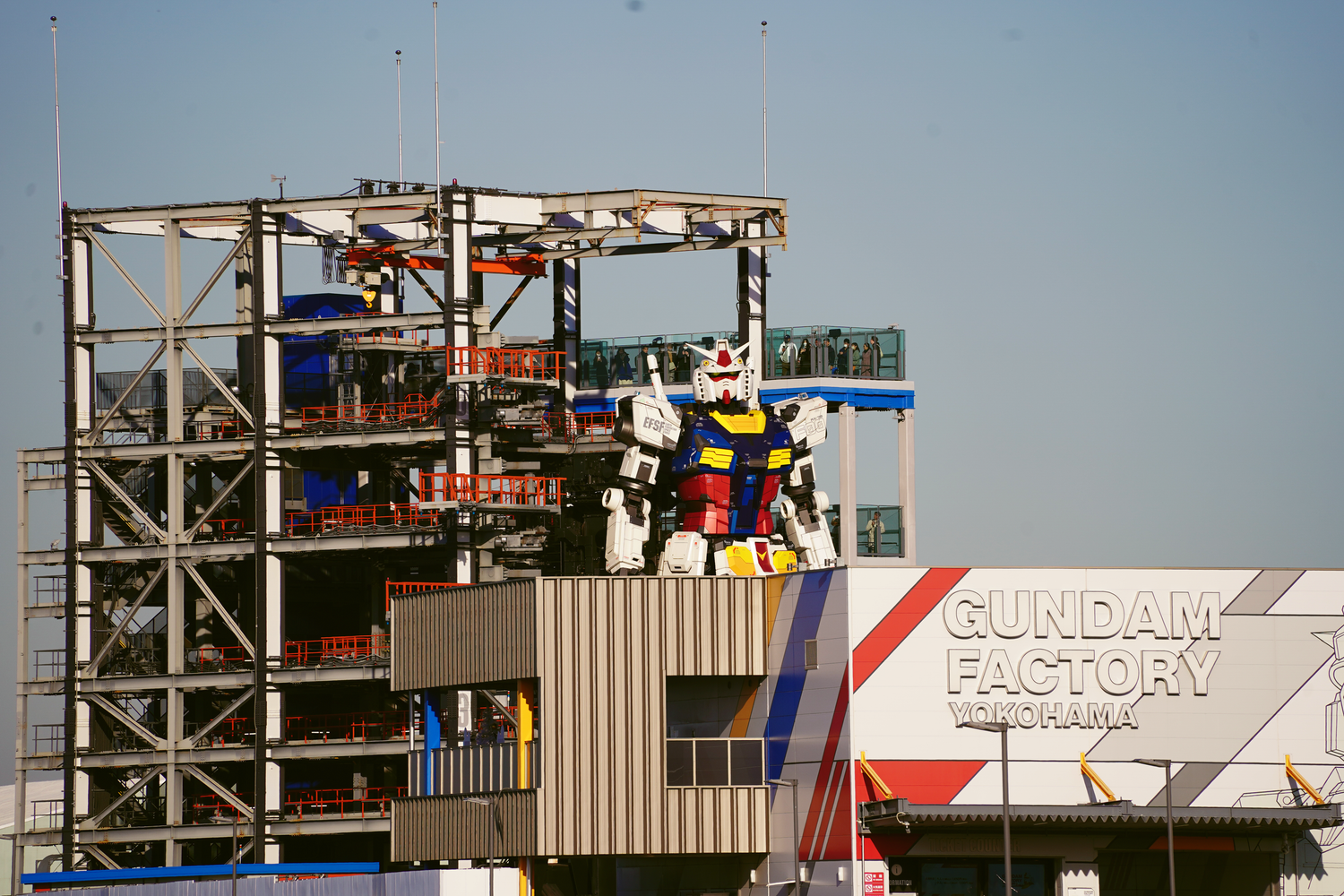Giant Gundam robot statue at Gundam Factory Yokohama waterfront attraction in Japan.