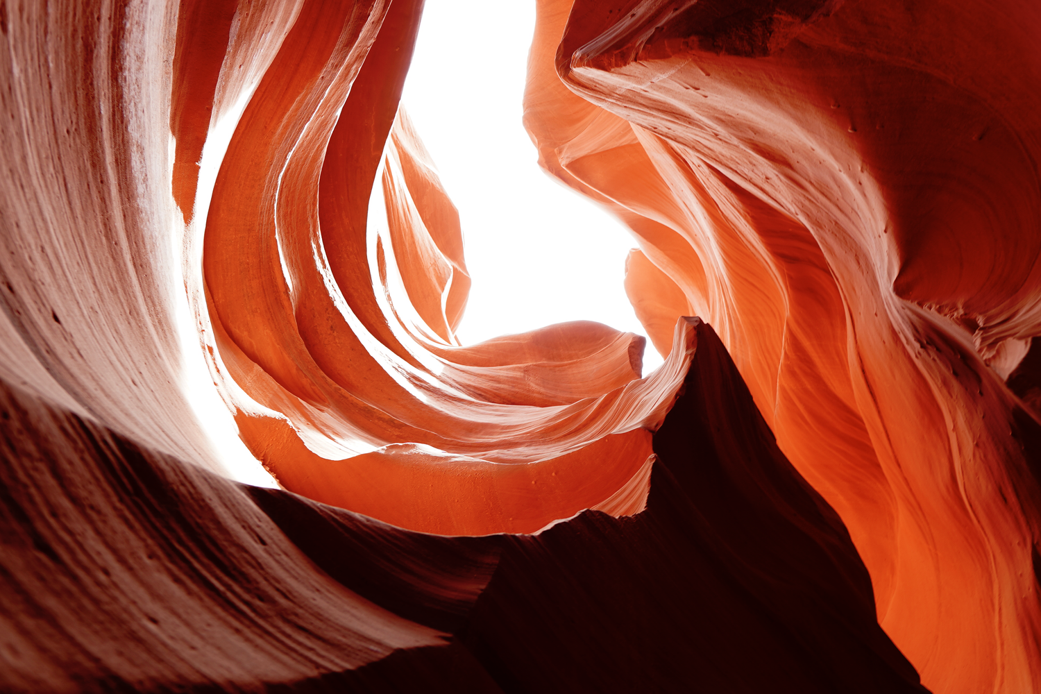 Breathtaking swirling red and orange sandstone walls glowing with light inside Antelope Canyon.