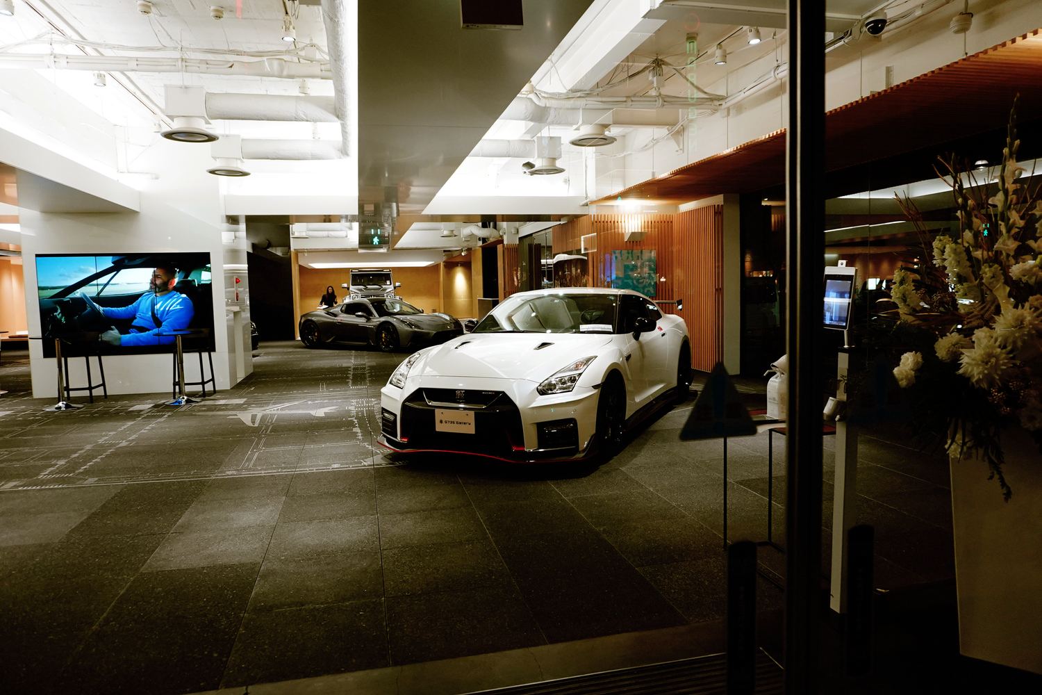 White Nissan GT-R NISMO sports car displayed in a modern showroom interior.