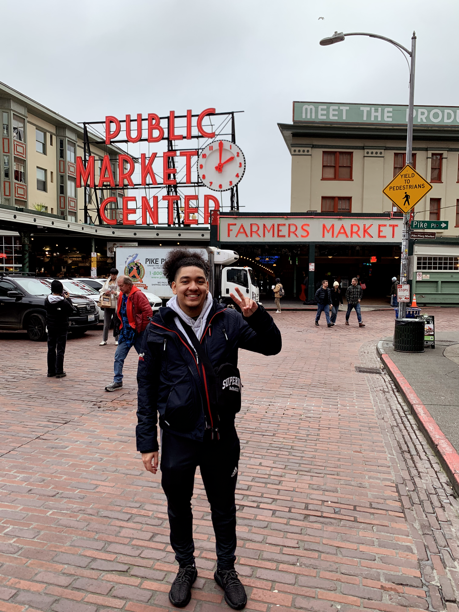 Man posing with peace sign at Pike Place Public Market Center Farmers Market in Seattle, Washington.