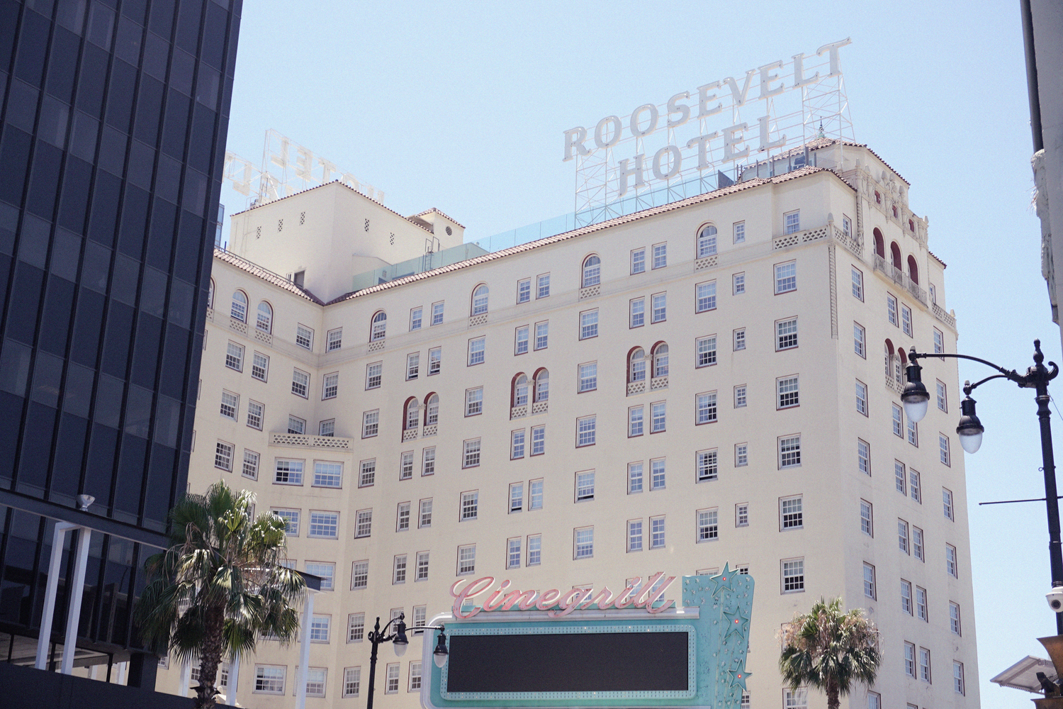 Historic Hollywood Roosevelt Hotel facade with white exterior and signage against a clear sky in California.