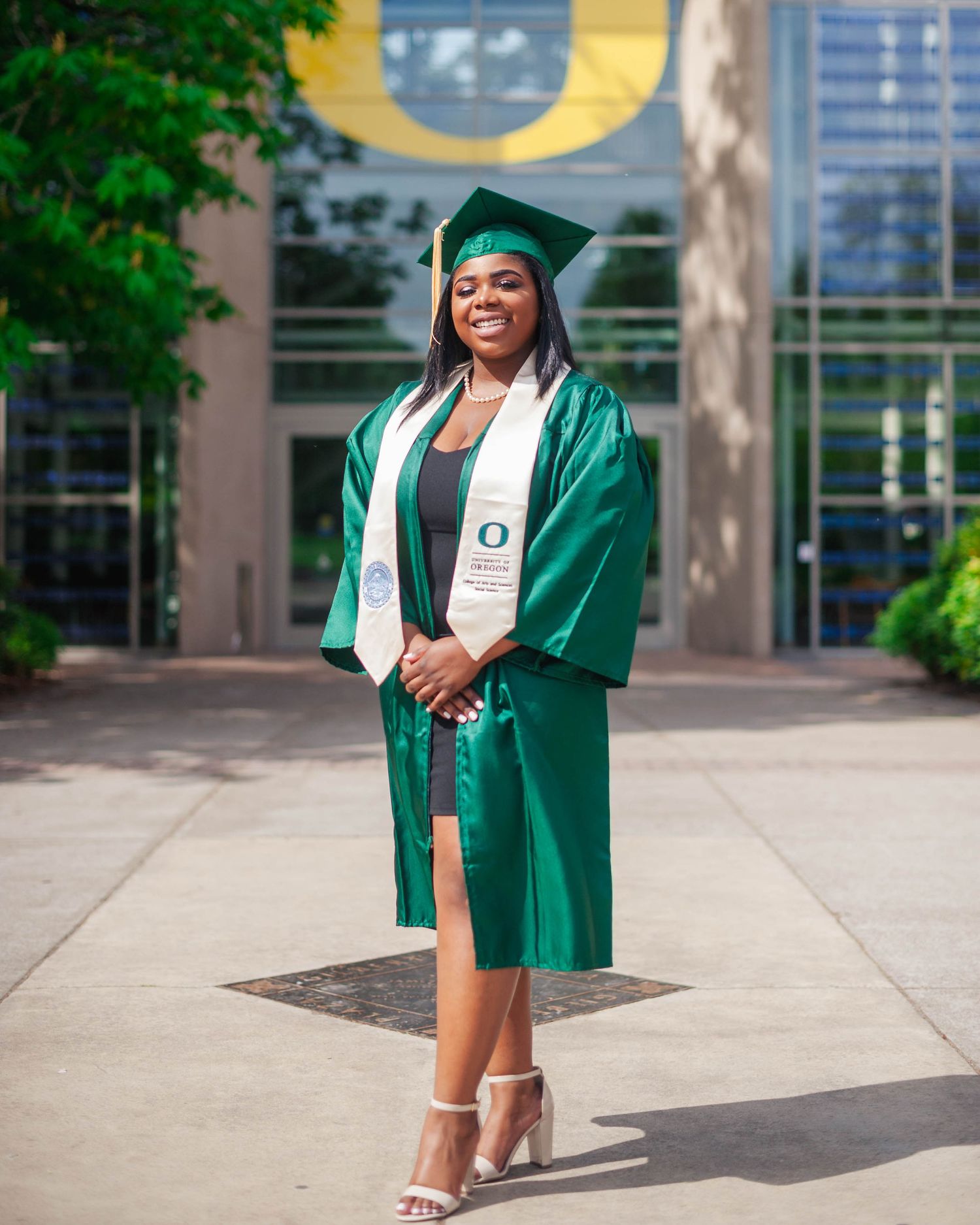 Senior graduation portrait on University of Oregon campus — cap and gown photography