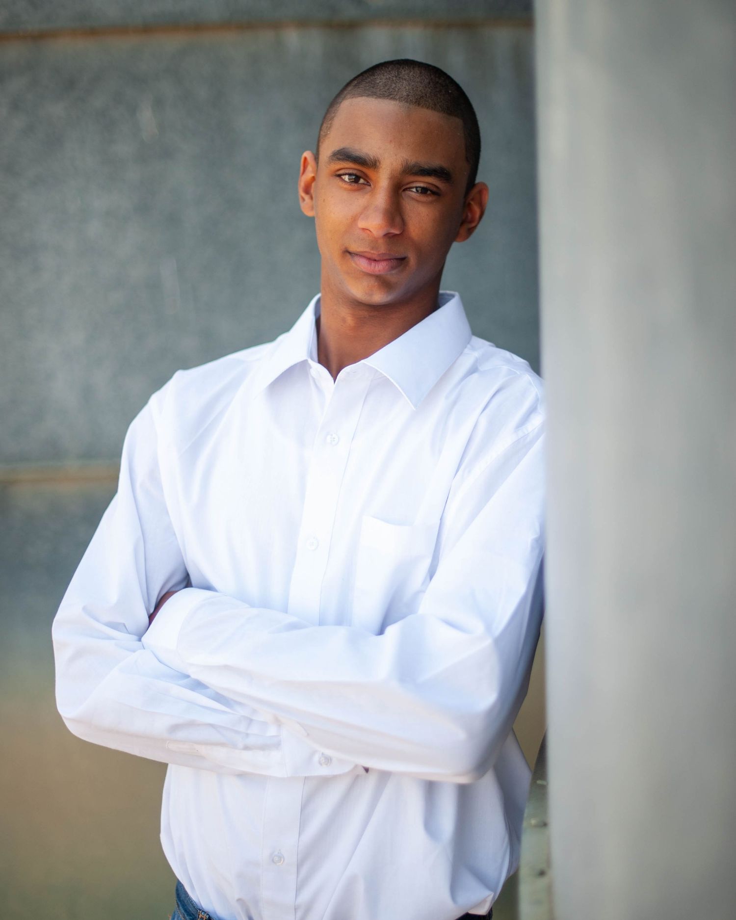 Senior portrait — young man in white shirt against architectural columns, Bay Area senior photographer