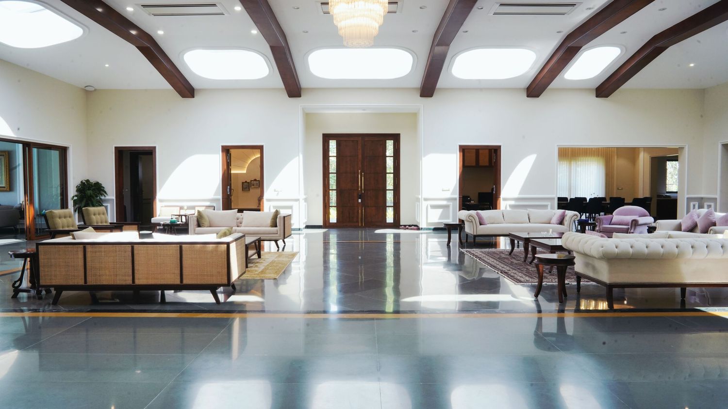 Large open room with exposed wooden beams and natural lighting through skylights.
