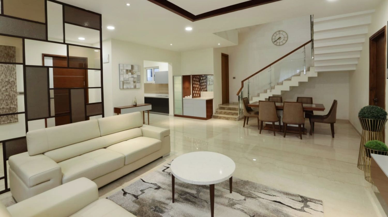 Luxurious white marble lobby with modern furniture and staircase in panoramic view.
