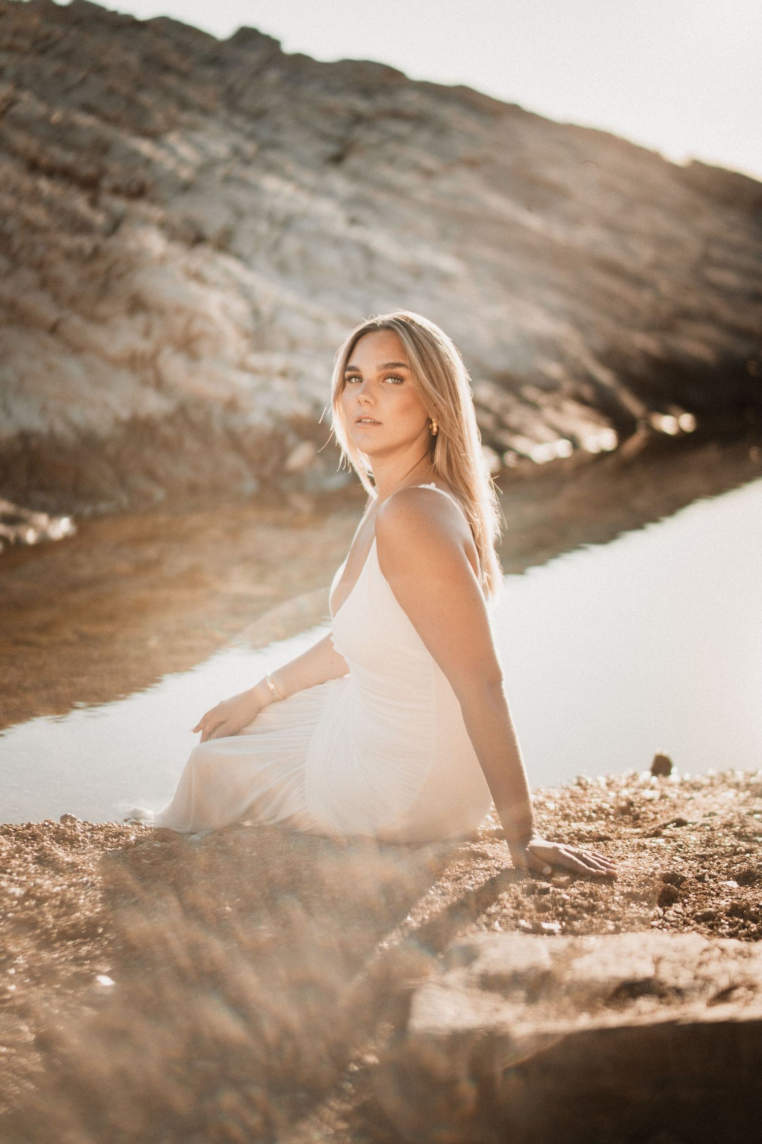 Portrait artistique en lumière dorée à Montpellier, femme assise au bord de l’eau