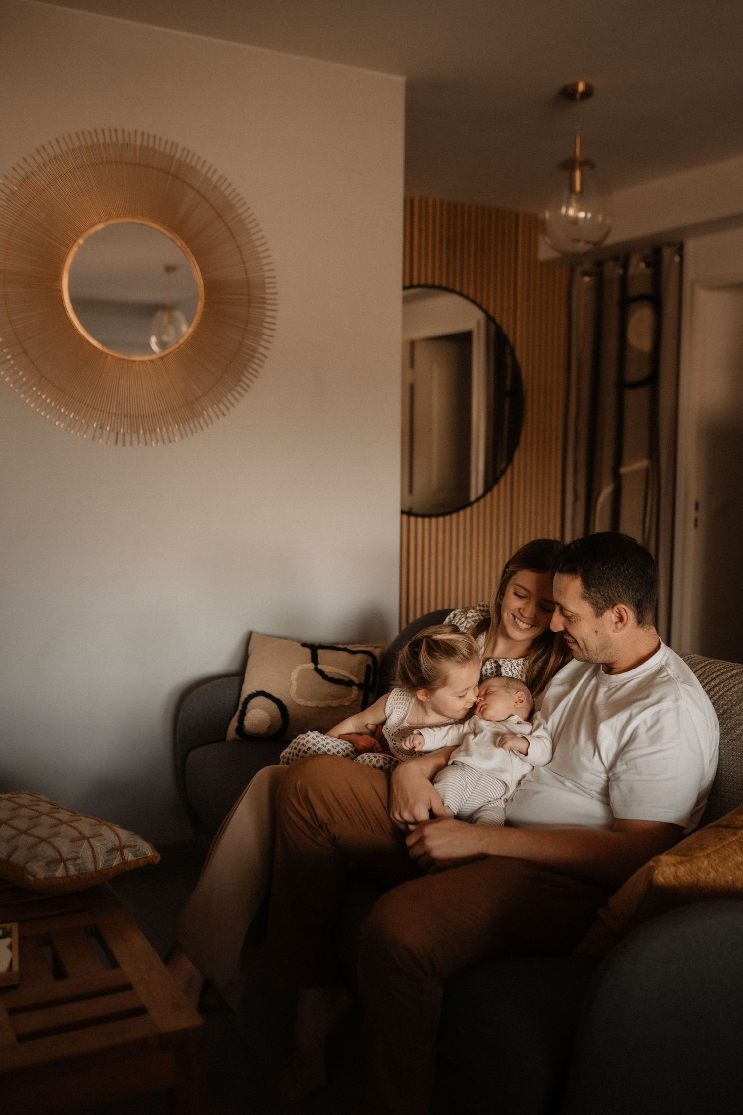 Séance photo famille et naissance à Montpellier à domicile, parents et enfants réunis sur un canapé