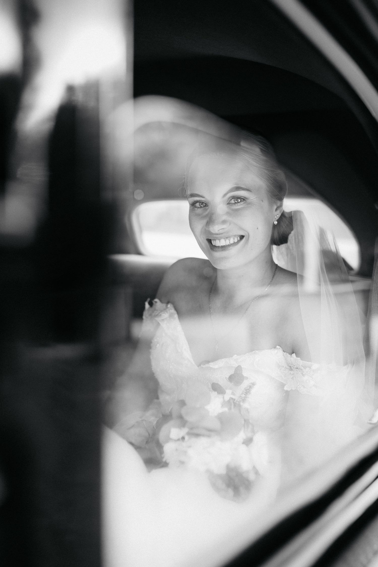 Mariée souriante dans une voiture le jour de son mariage à Montpellier
