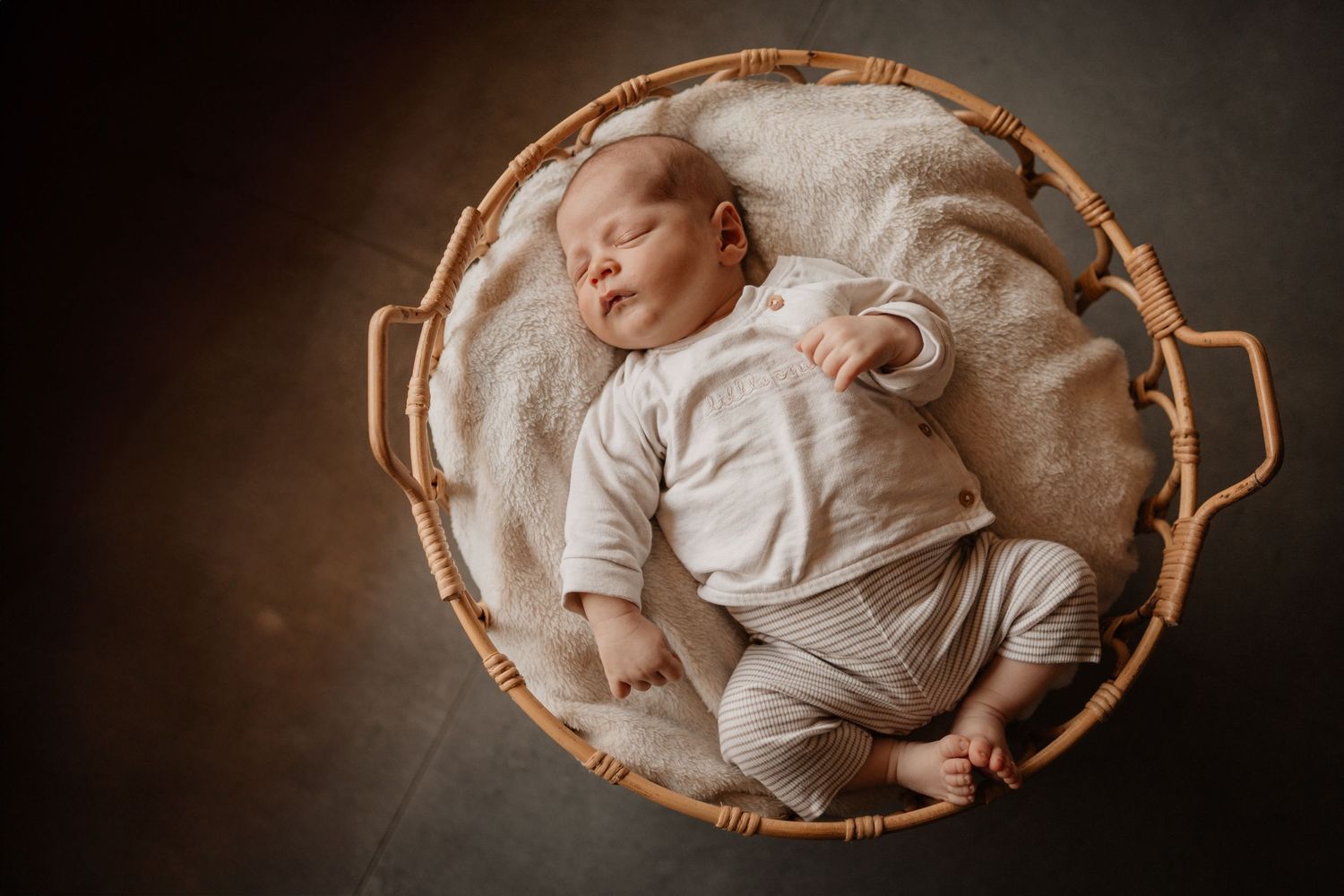 Séance bébé en panier en lumière douce naturelle