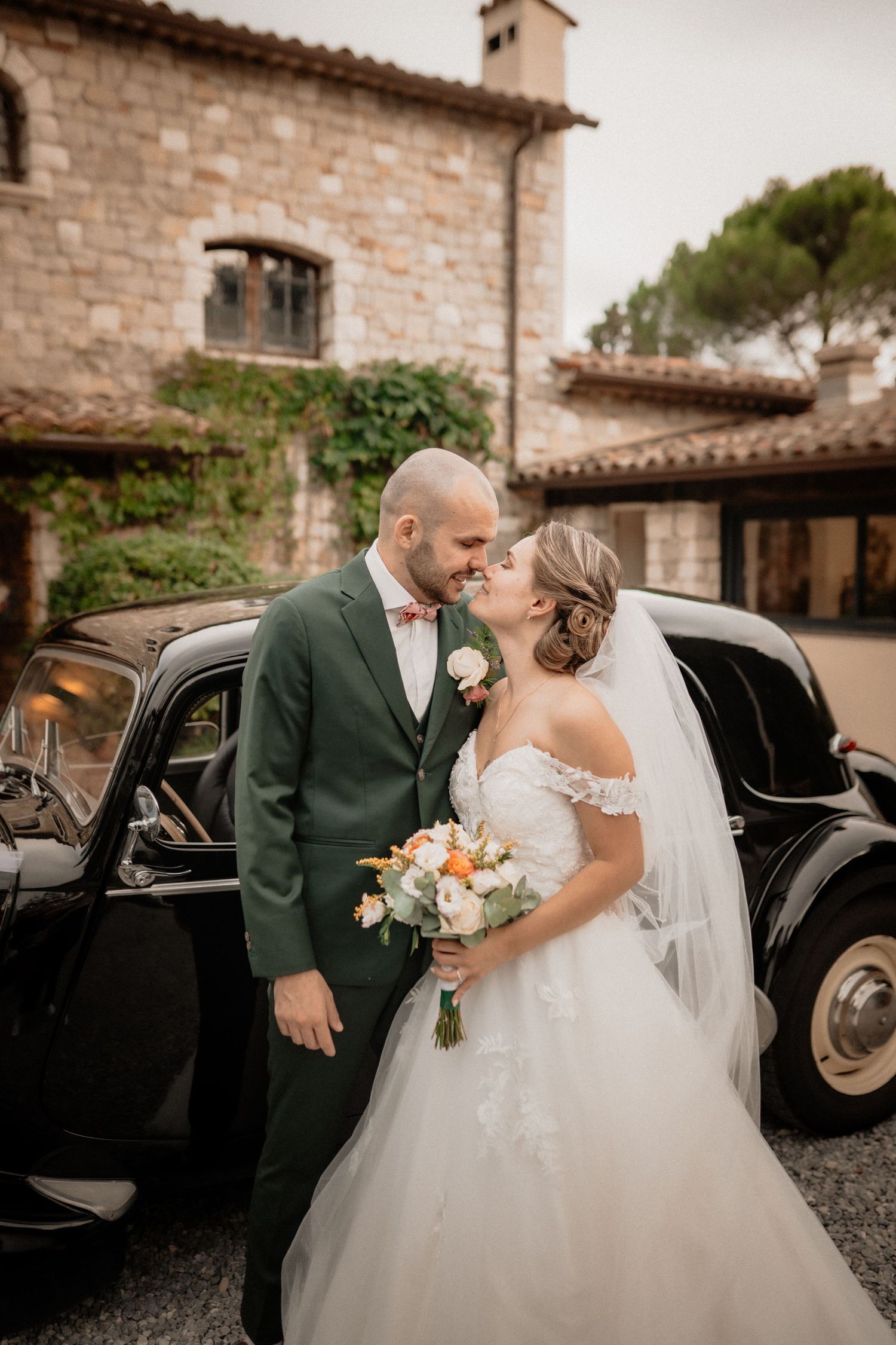 Couple de mariés près d’une voiture ancienne, mariage en Occitanie.