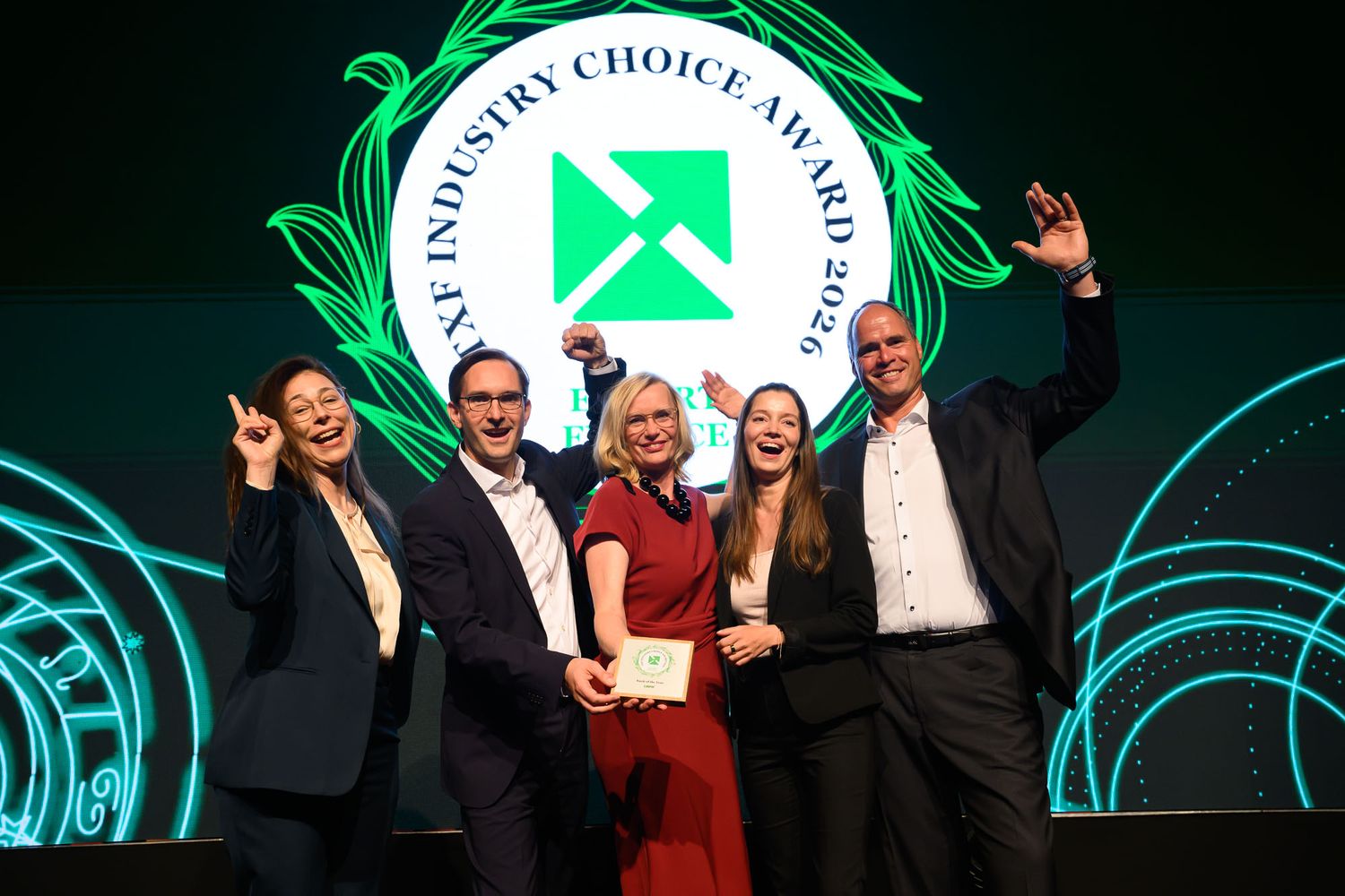 Five professionals celebrate on stage at the ANF Industry Choice Award 2024 ceremony, holding a trophy under green lights.