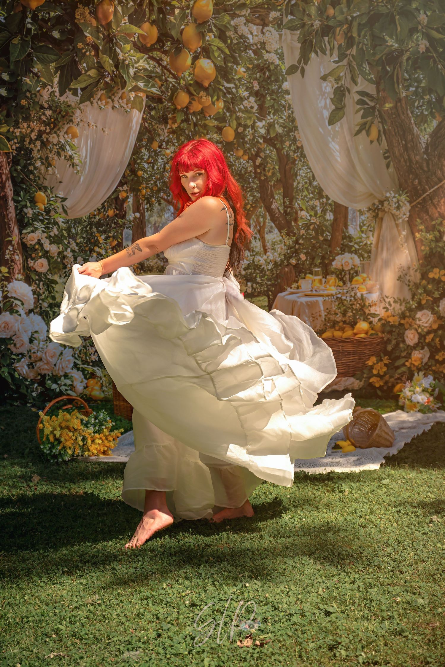 Woman with red hair twirling in white dress in a floral garden setting.