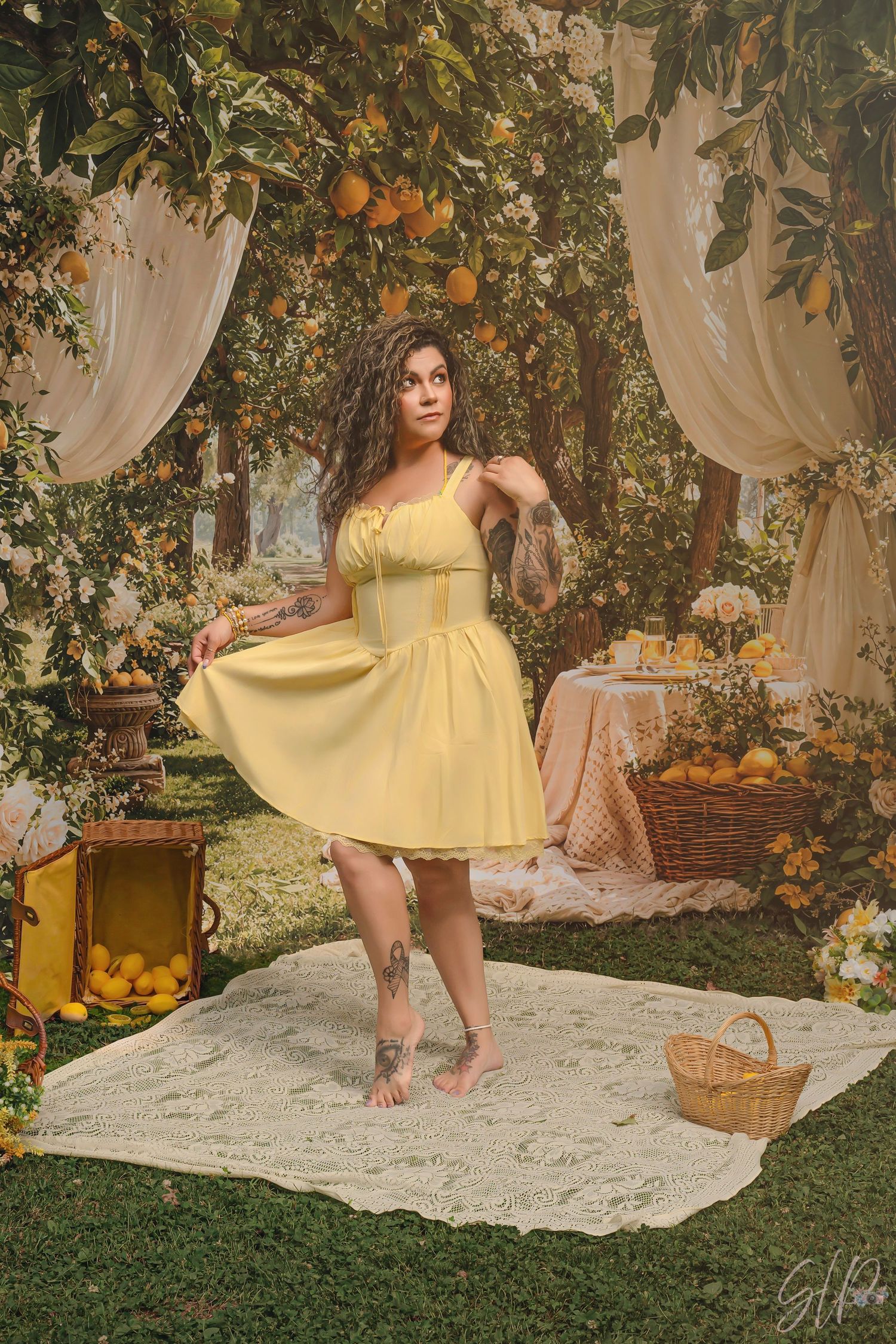Woman in yellow sundress twirling in a lemon garden with draped fabric and citrus decor.