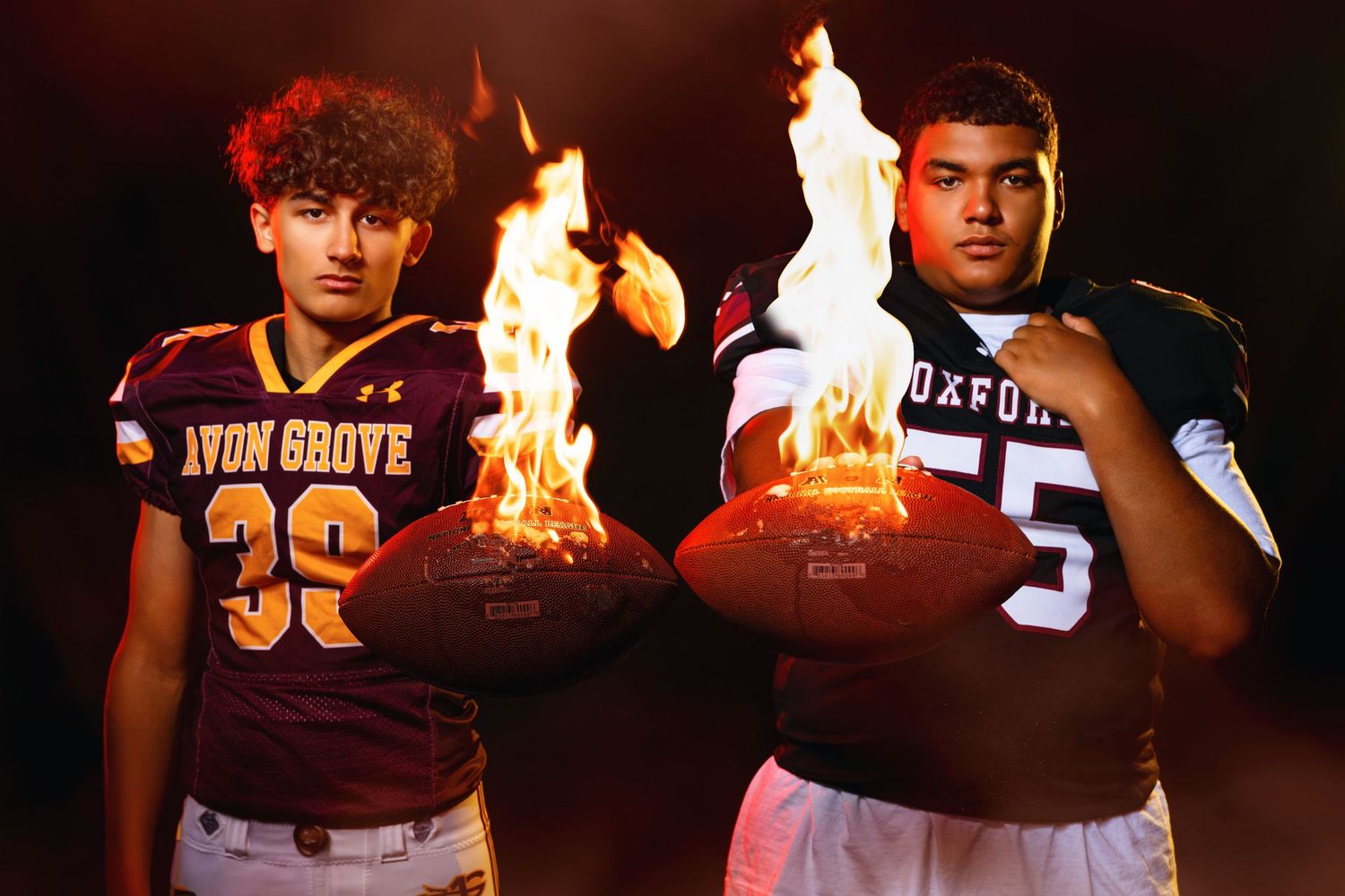 Avon Grove and Oxford football players hold flaming footballs in dramatic pregame rivalry photo.