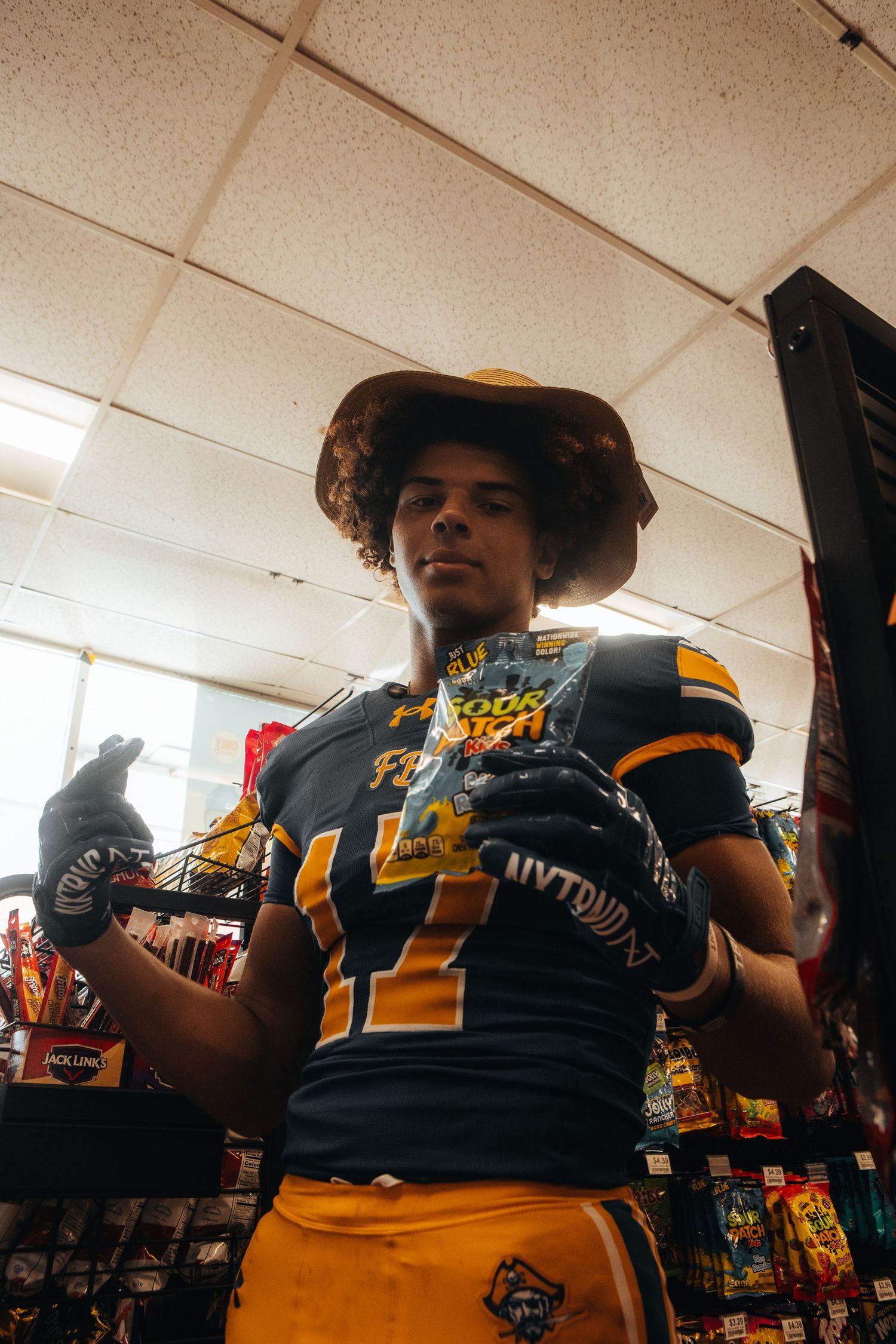 Sports fans in navy and gold team merchandise browse a retail store.
