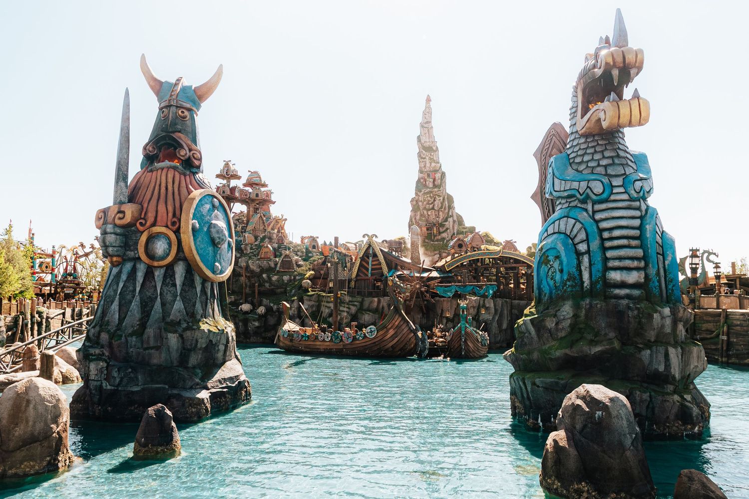 Viking-themed fantasy water attraction with colorful totem statues and turquoise lagoon at a theme park.