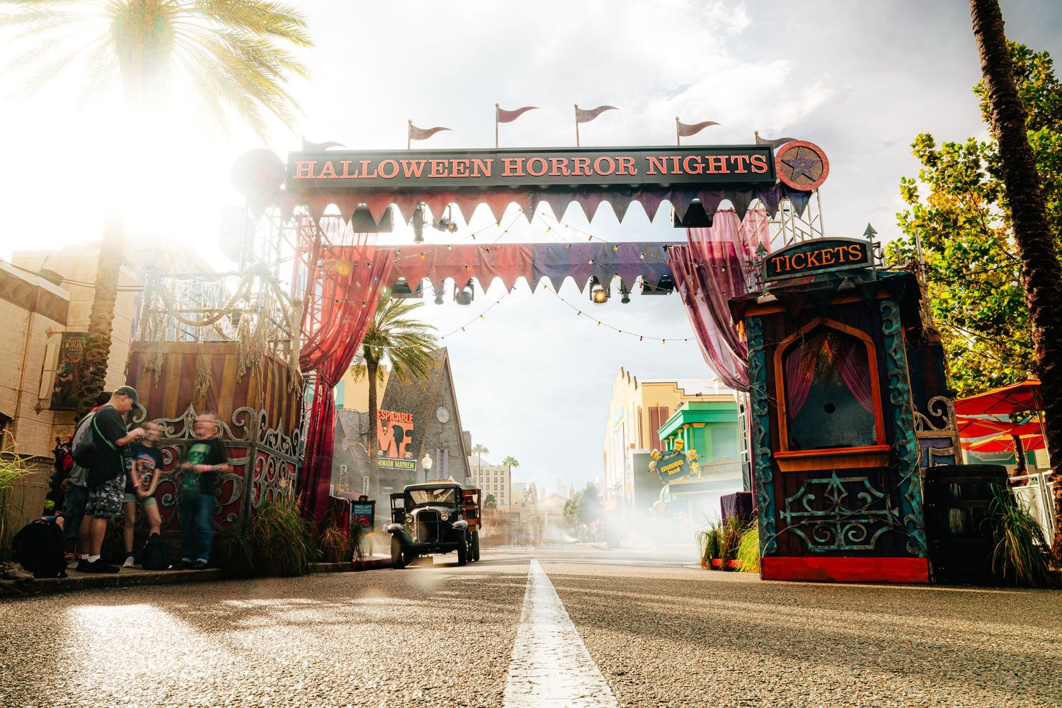 Halloween Horror Nights entrance arch with spooky decorations, red curtains, and misty atmosphere at Universal Studios theme park.