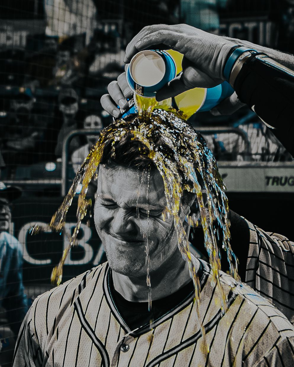 Baseball player gets celebratory sports drink shower after game.