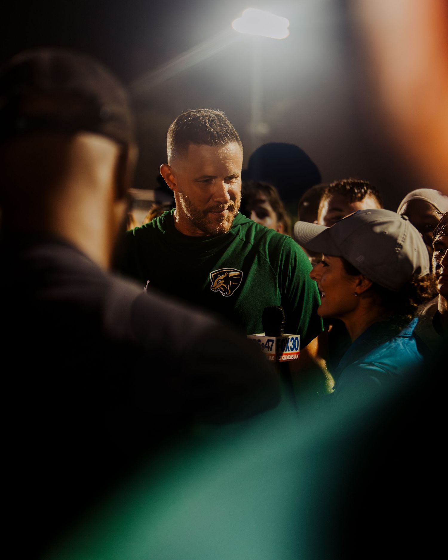 Sports fans gather in dim lighting during an intense moment.