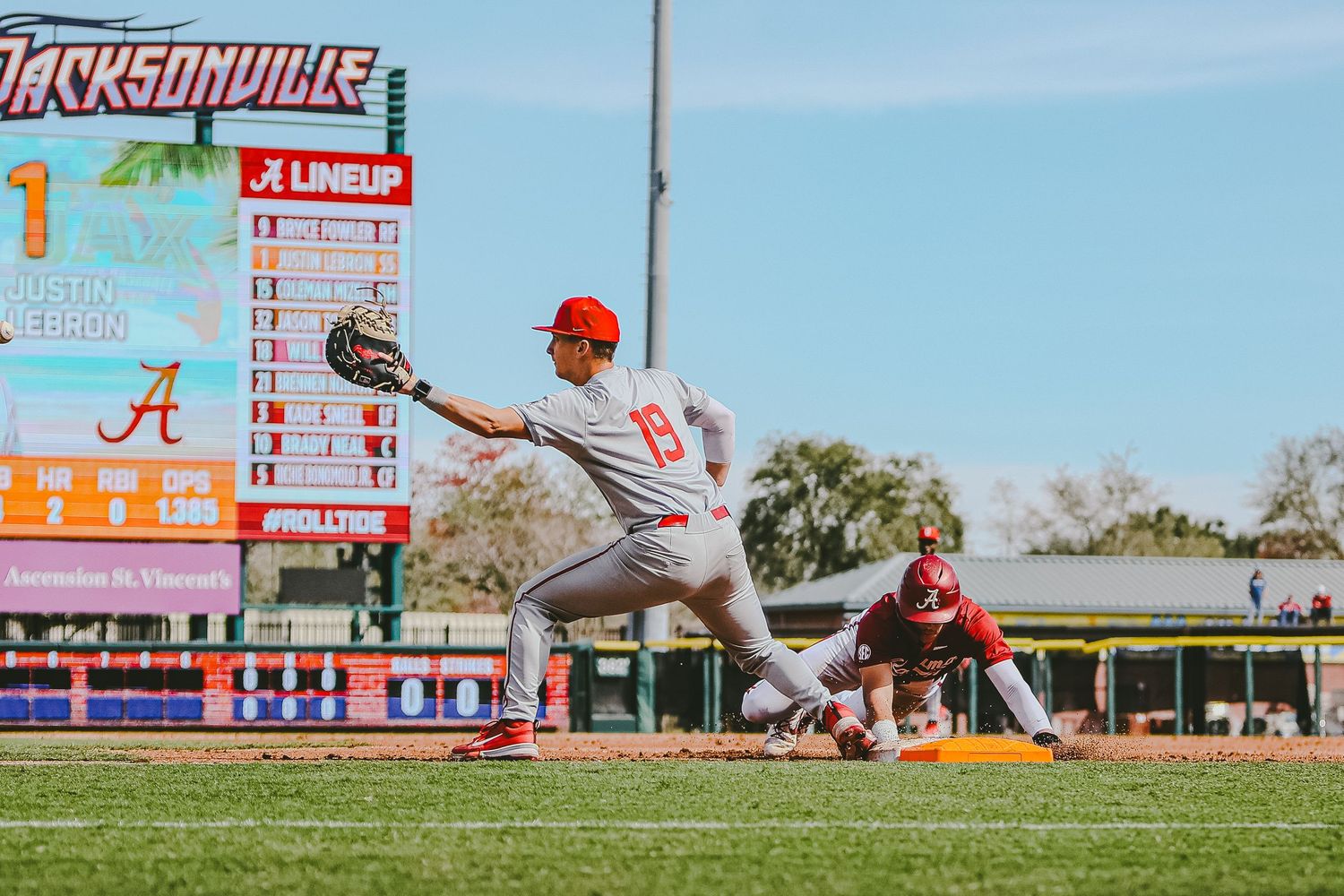 Baseball player stretches to make catch during game at Jacksonville stadium.