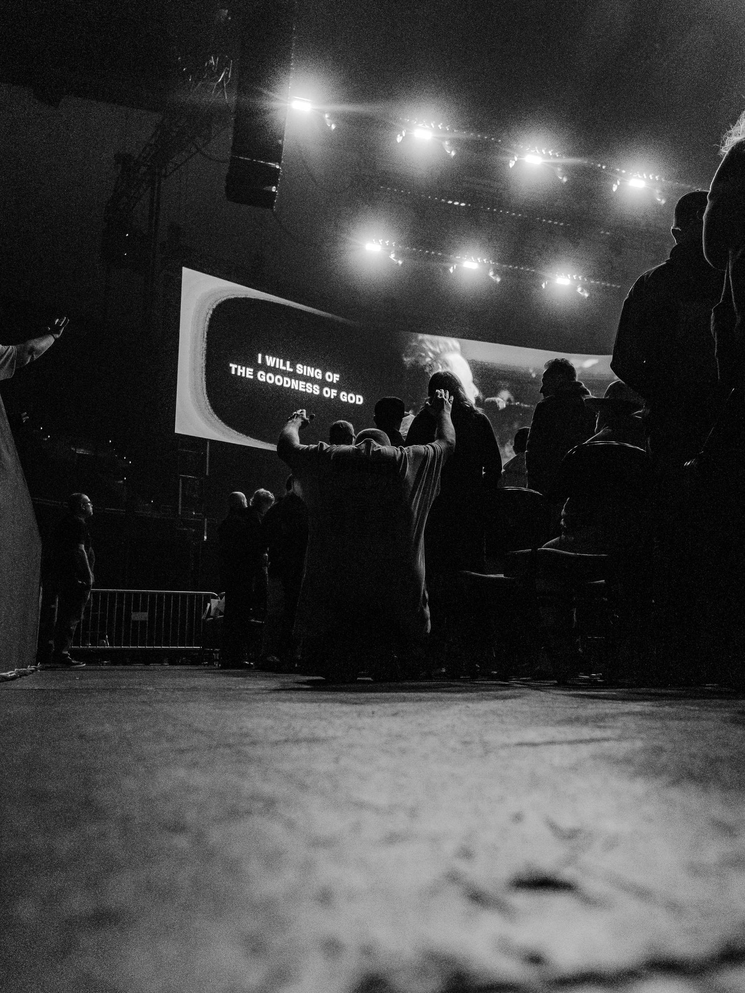 Dramatic low-angle black and white concert shots showing silhouettes of performers against bright stage lights.