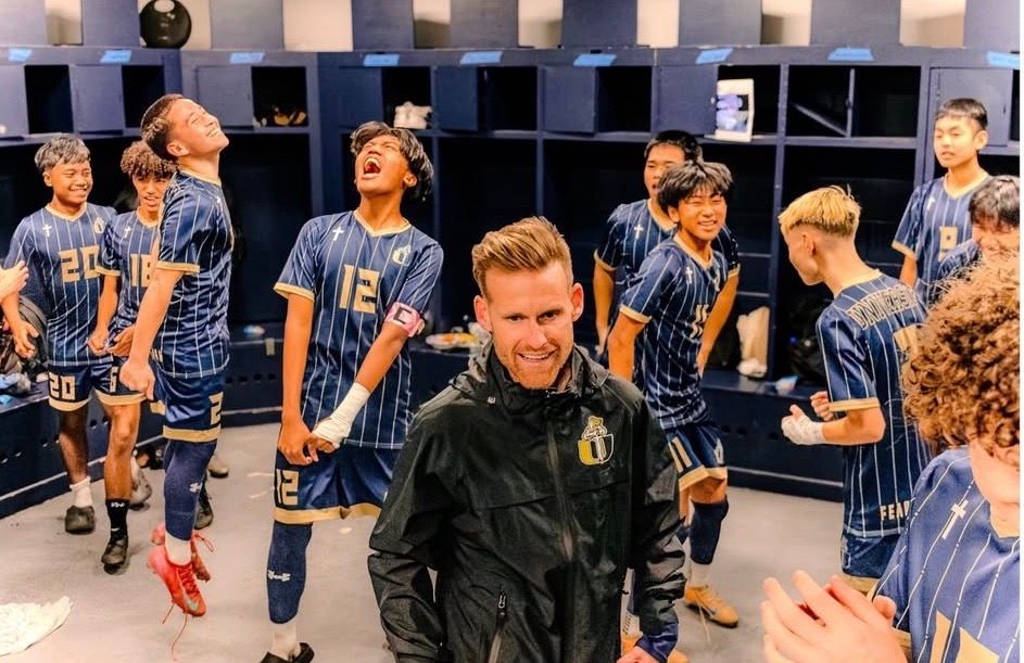 Athletes in matching striped uniforms gathered in locker room before game.