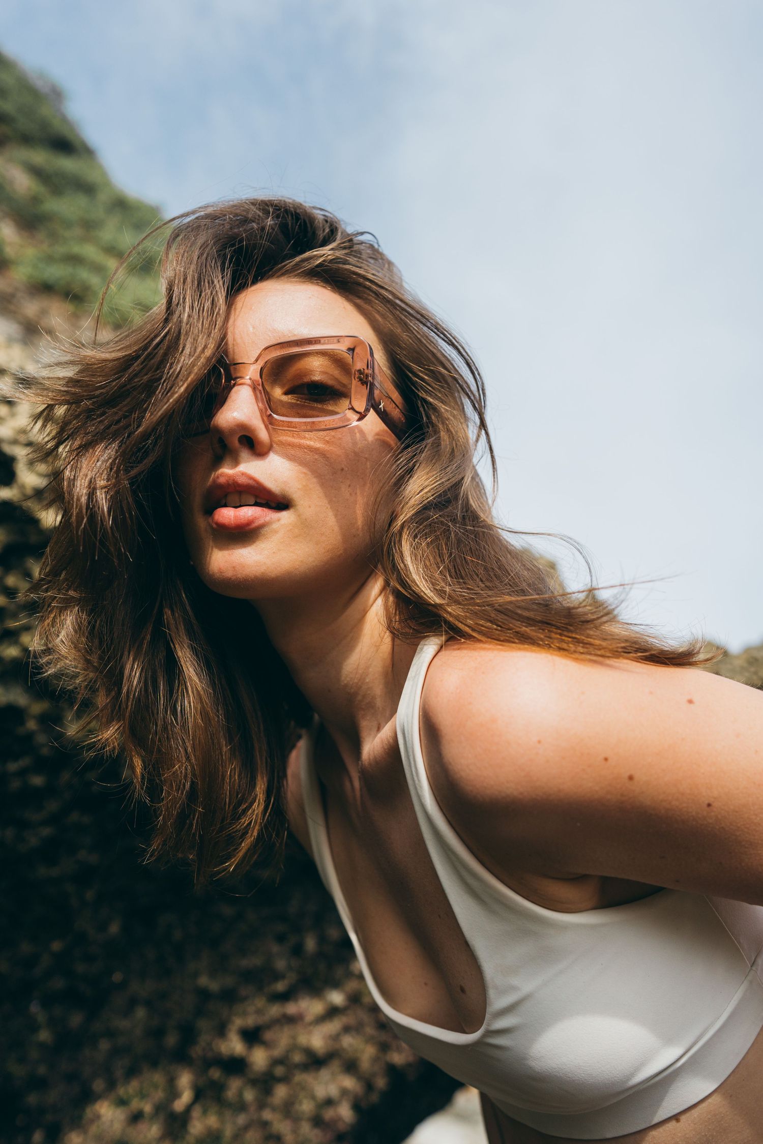 Close-up portrait of woman leaning forward outdoors in natural light.