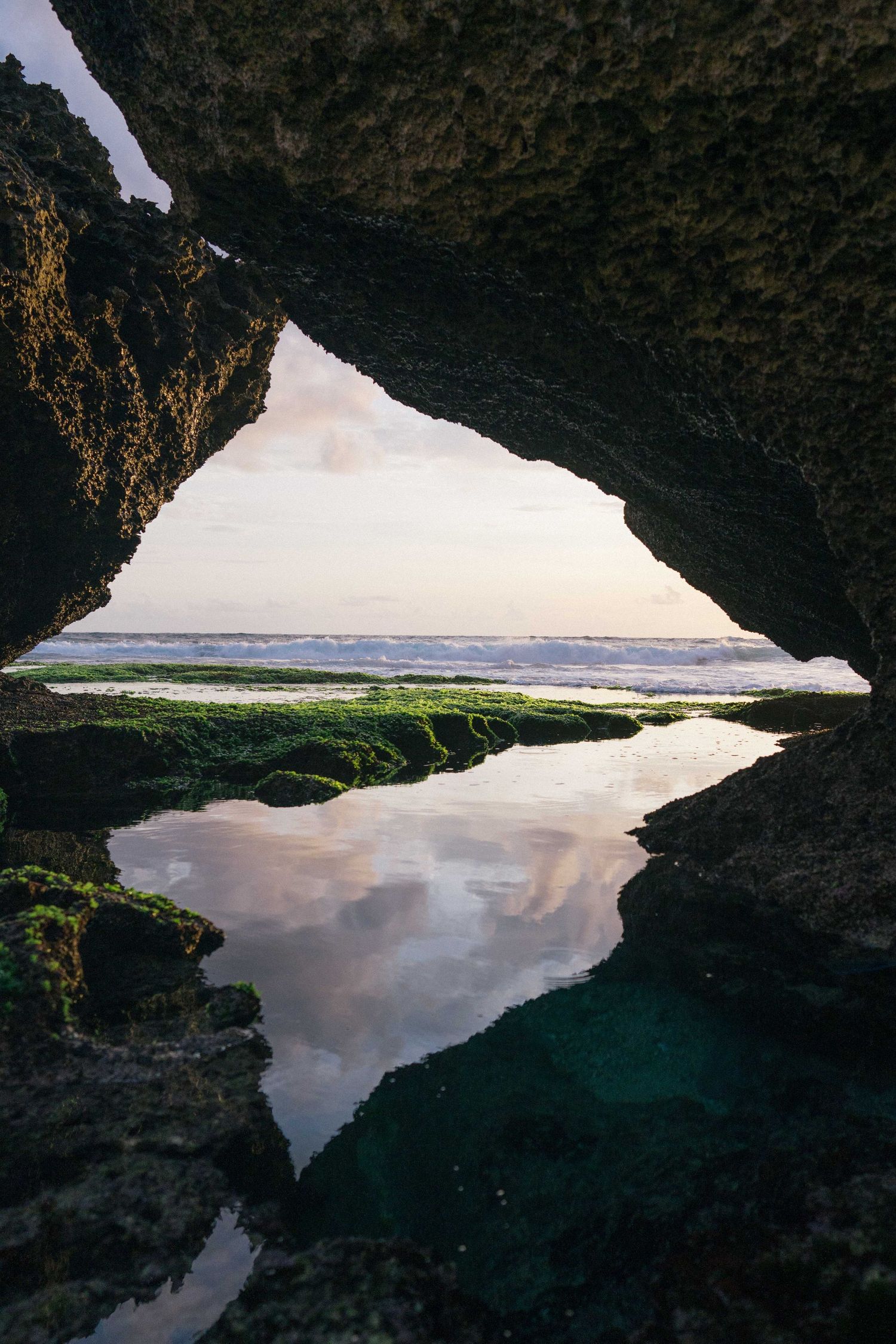 Coastal rock formation framing shallow tide pool and ocean horizon.