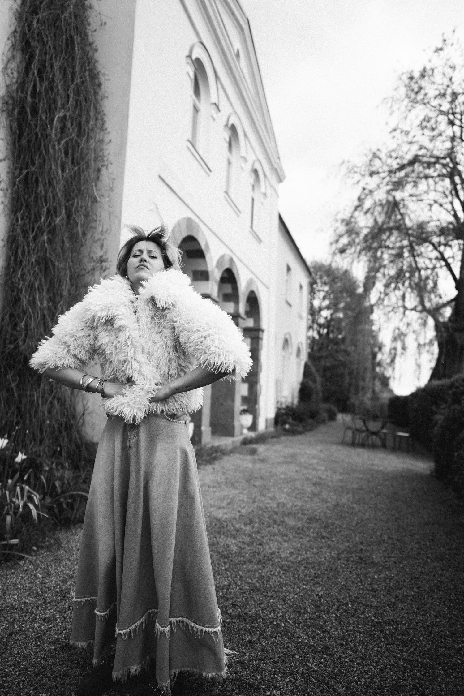 Black and white portrait of woman standing confidently outside a historic building