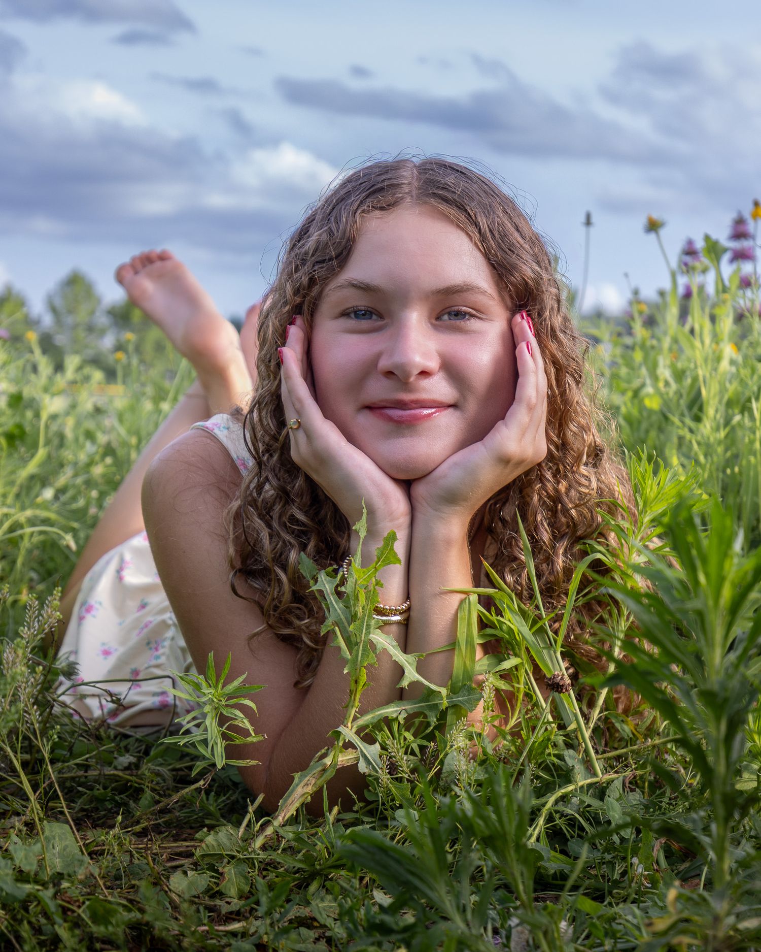 Senior portrait of a young lady standing in flowers at English Landing Park in Parkville | Kansas City Northland Portrait Photographer