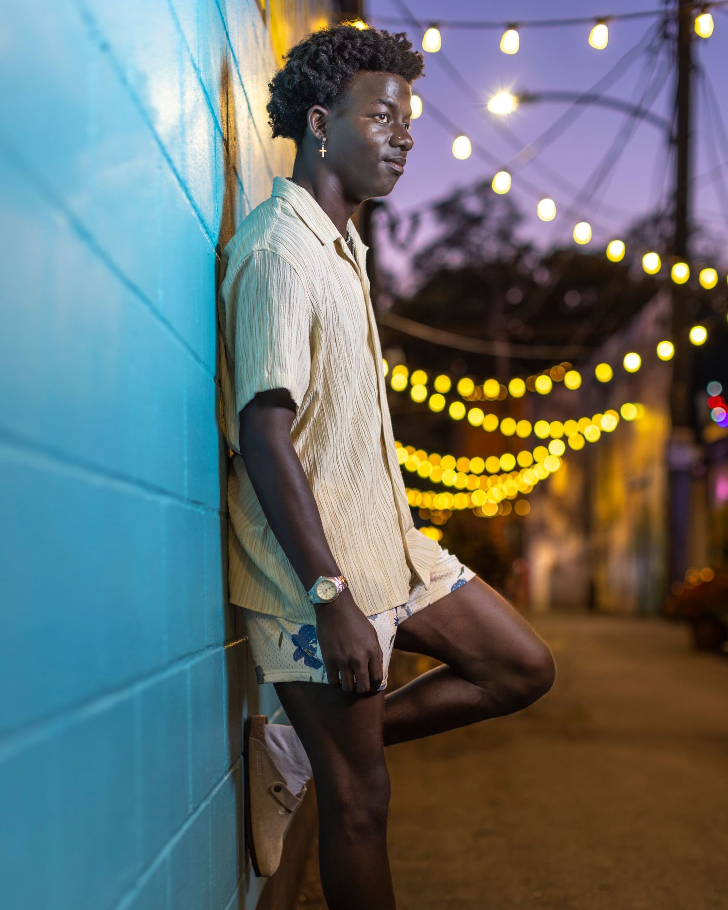 Colorful senior portrait photo of a young man leaning against a wall in Downtown Parkville | Kansas City Northland Portrait Photographer