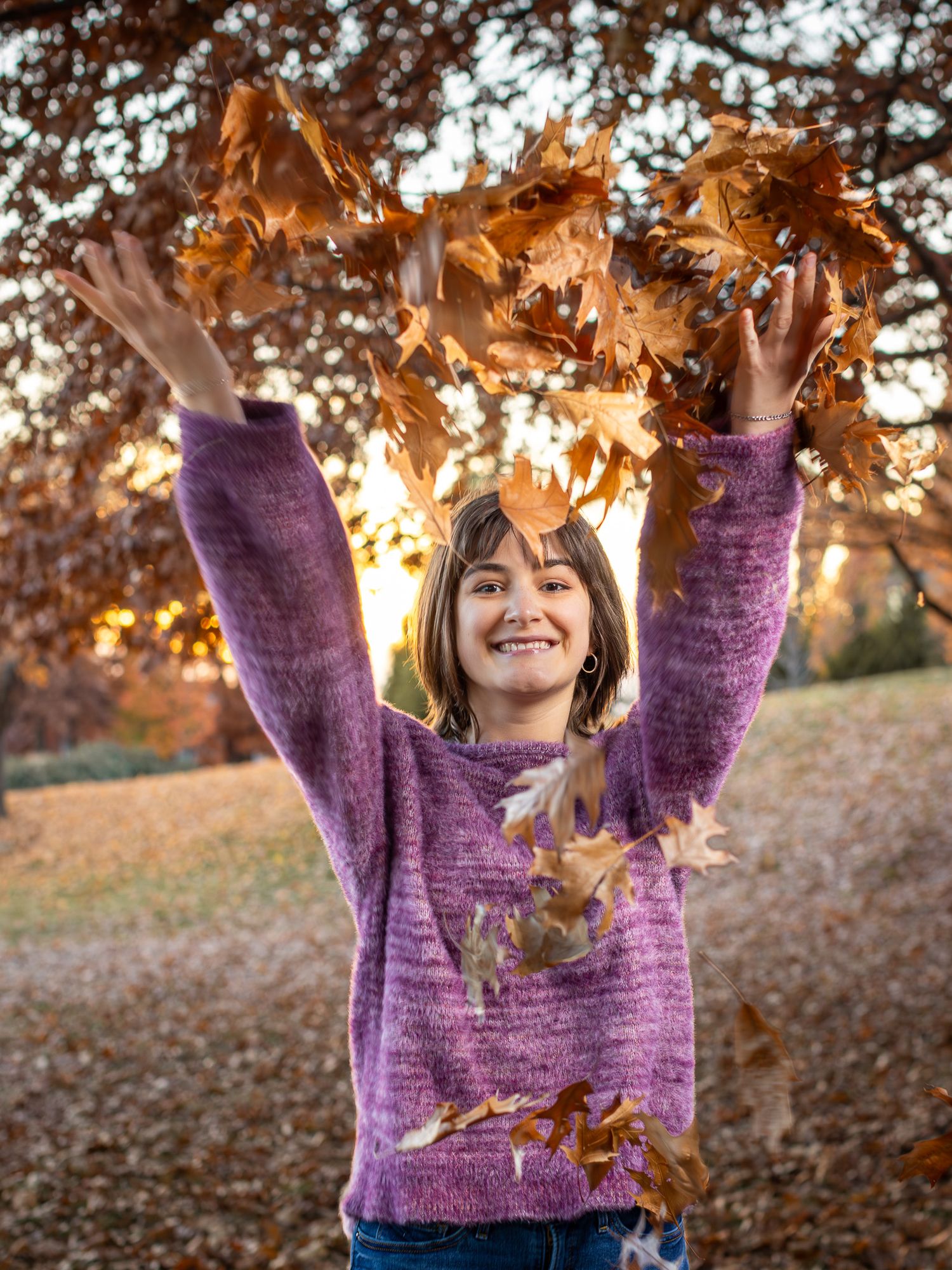 Photo of a young lady tossing fall leaves in the air at Charles A. Garney Park near Briarcliff | Kansas City Northland Portrait Photographer