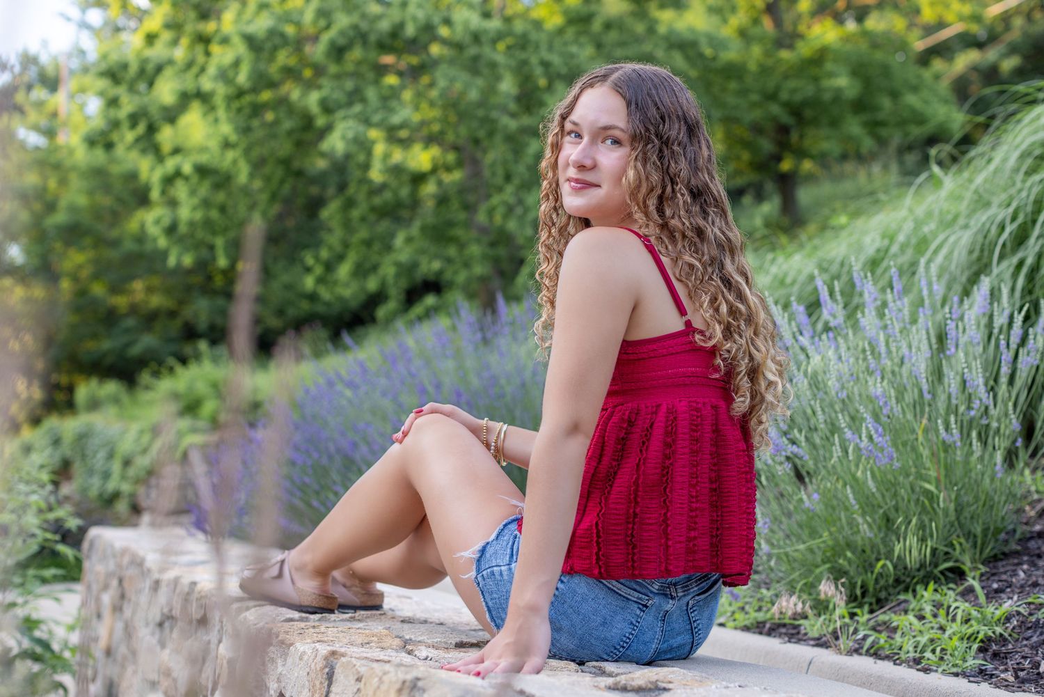 Senior portrait of a young sitting on block wall at Park University in Parkville | Kansas City Northland Portrait Photographer