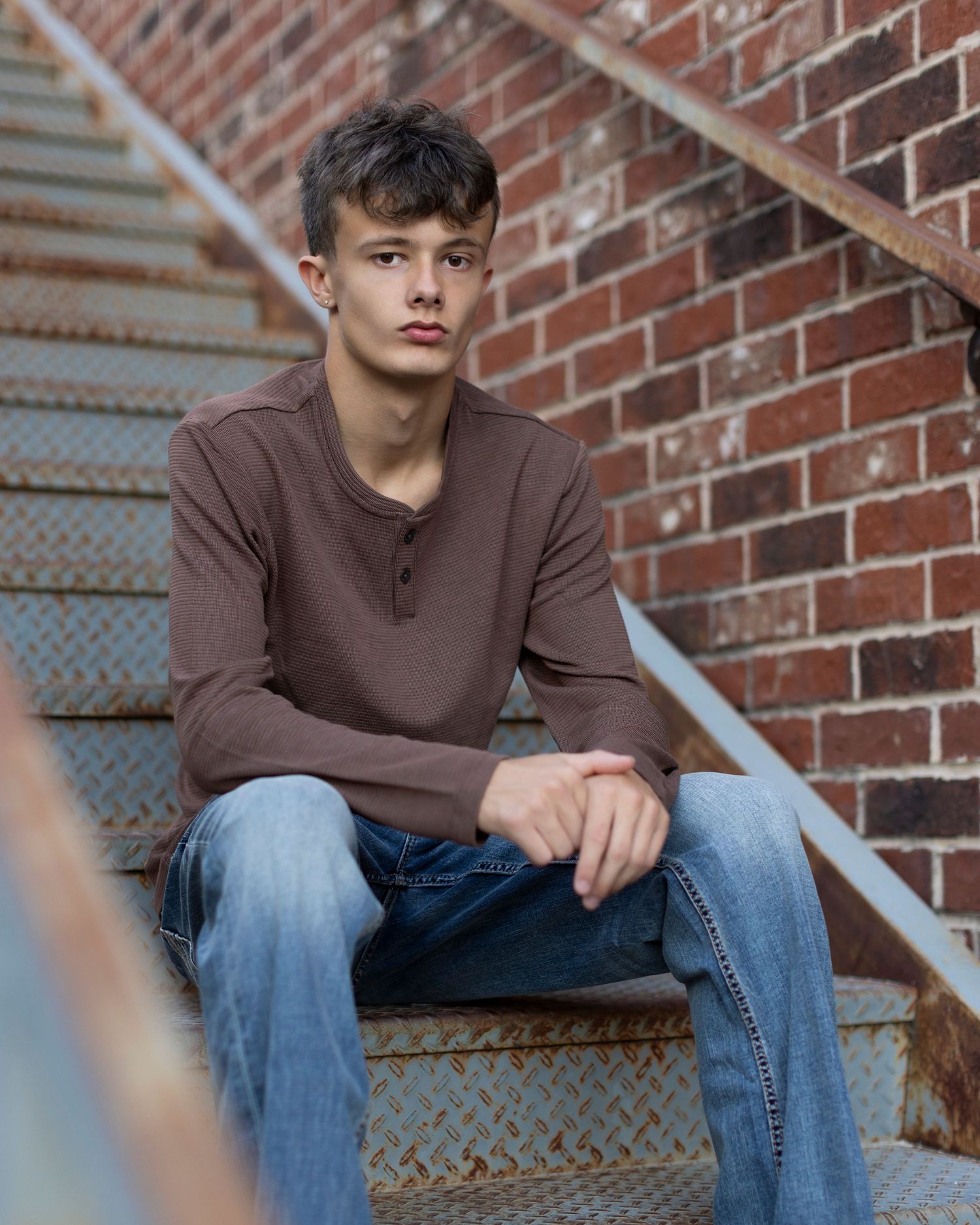 Senior portrait photo of a young man sitting on steps in Downtown Parkville | Kansas City Northland Portrait Photographer