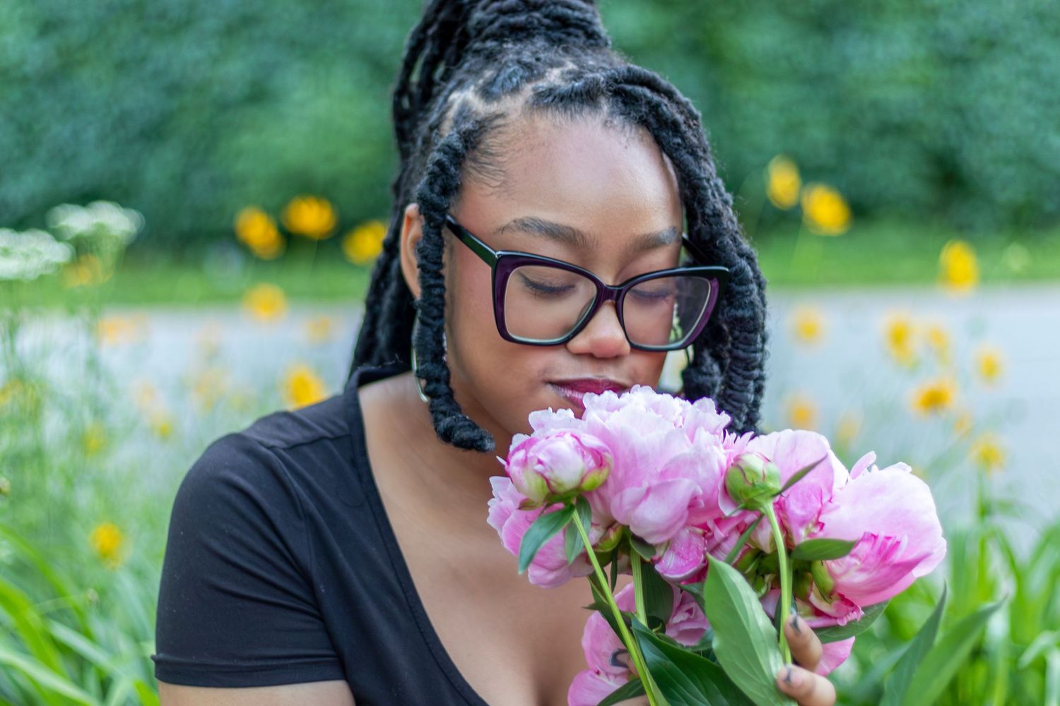KC portrait photography. Professional senior photo of a young woman smelling peonies.