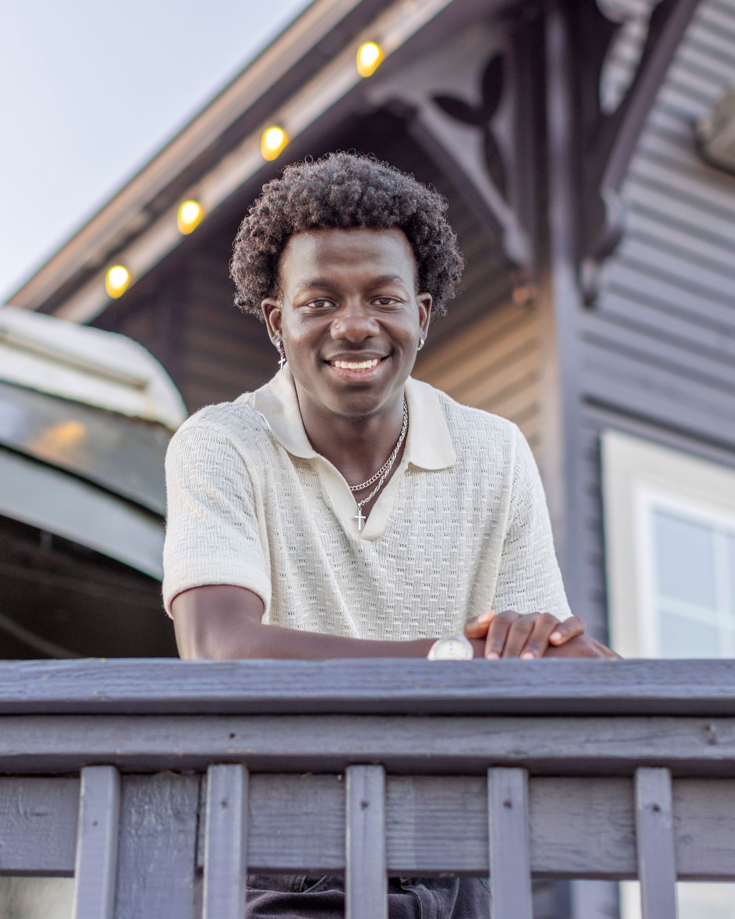 Senior portrait photo of a young man leaning on a rail taken in Downtown Parkville | Kansas City Northland Portrait Photographer