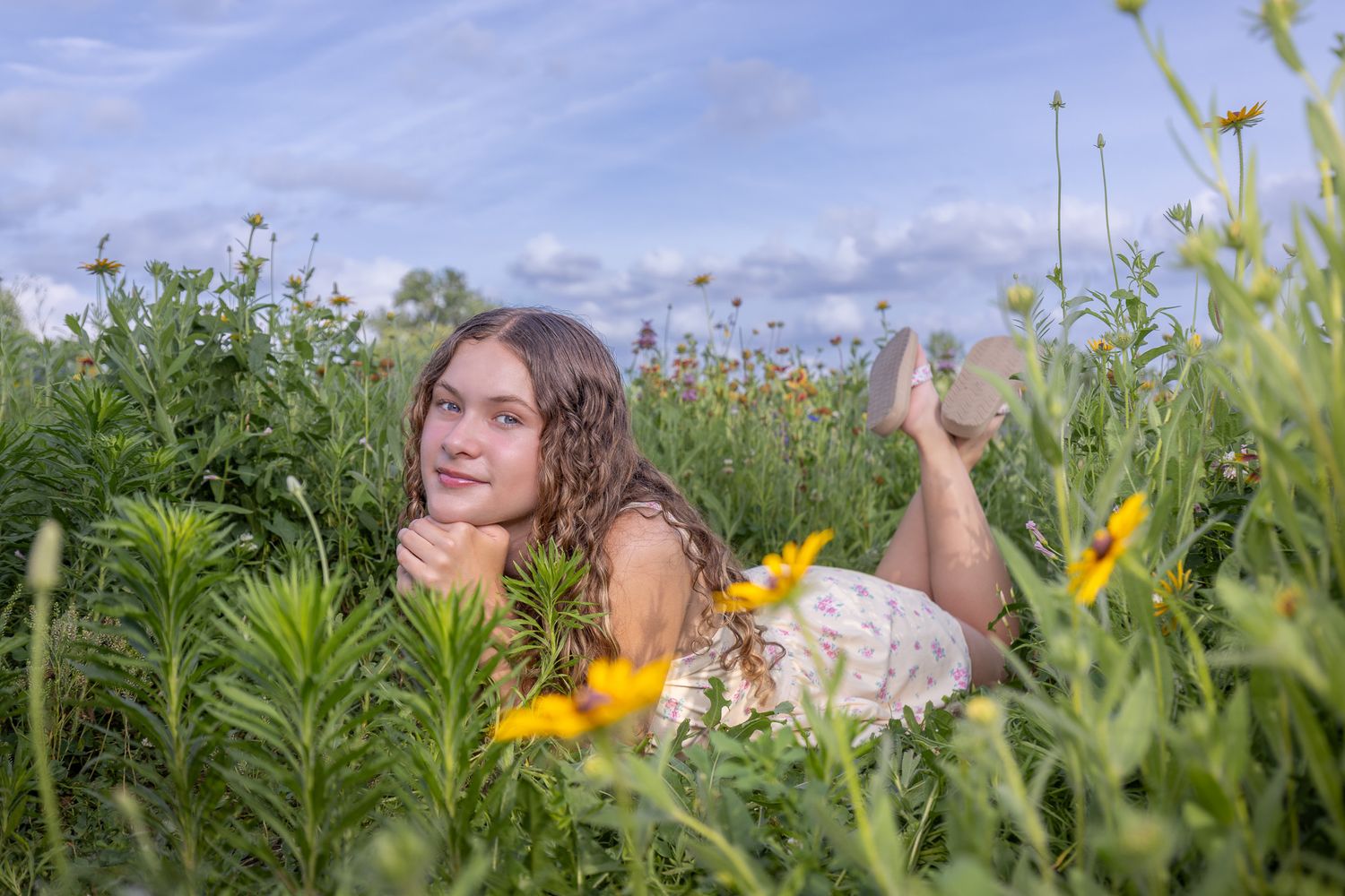 Senior portrait of a young lady laying in flowers at English Landing Park in Parkville | Kansas City Northland Portrait Photographer