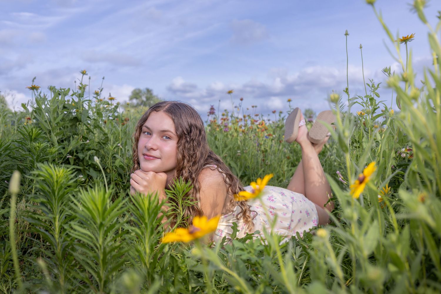 Senior portrait of a young lady laying in flowers at English Landing Park in Parkville | Kansas City Northland Portrait Photographer