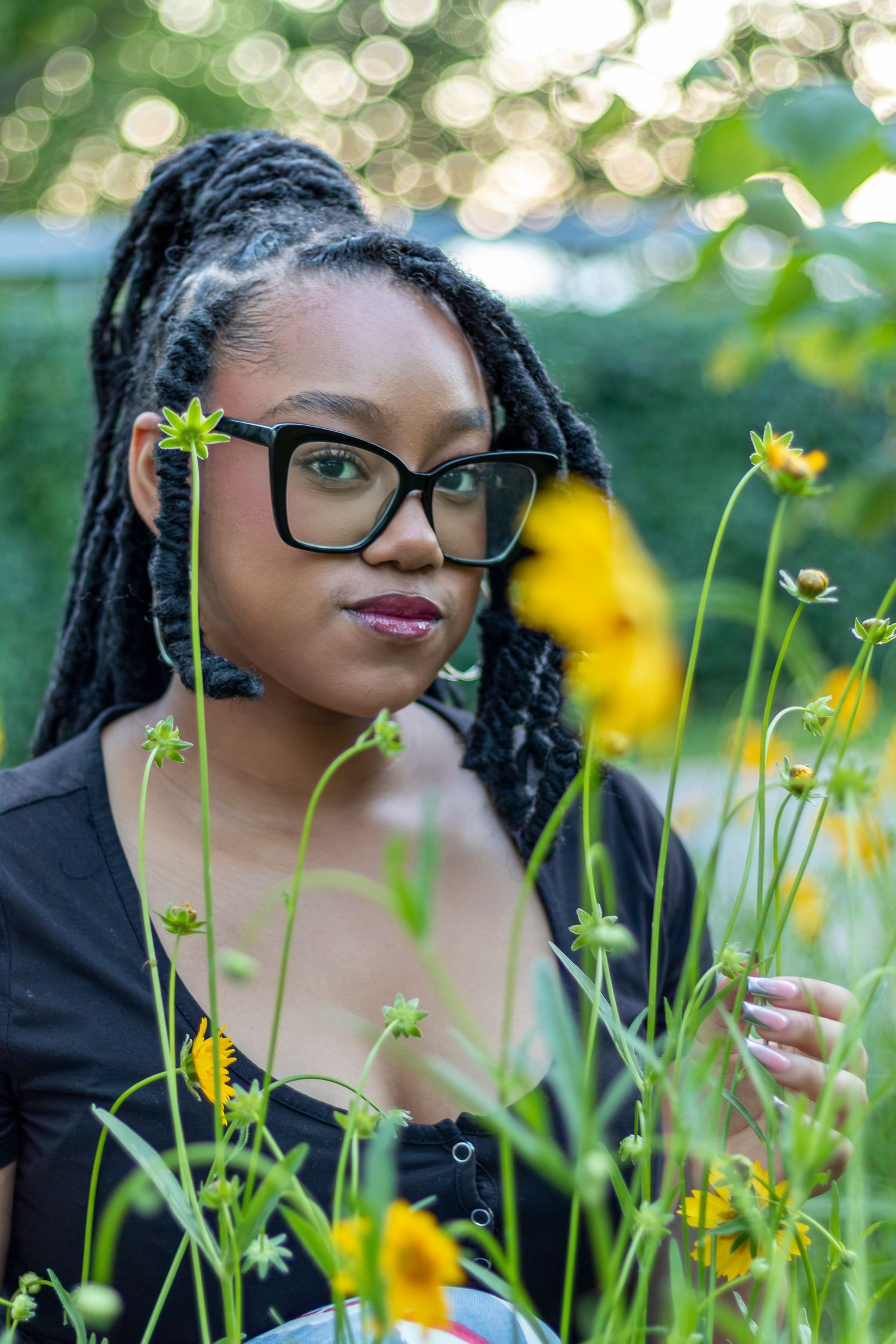 Senior portrait photo of a young lady smelling flowers at a location in Parkville | Kansas City Northland Portrait Photographer