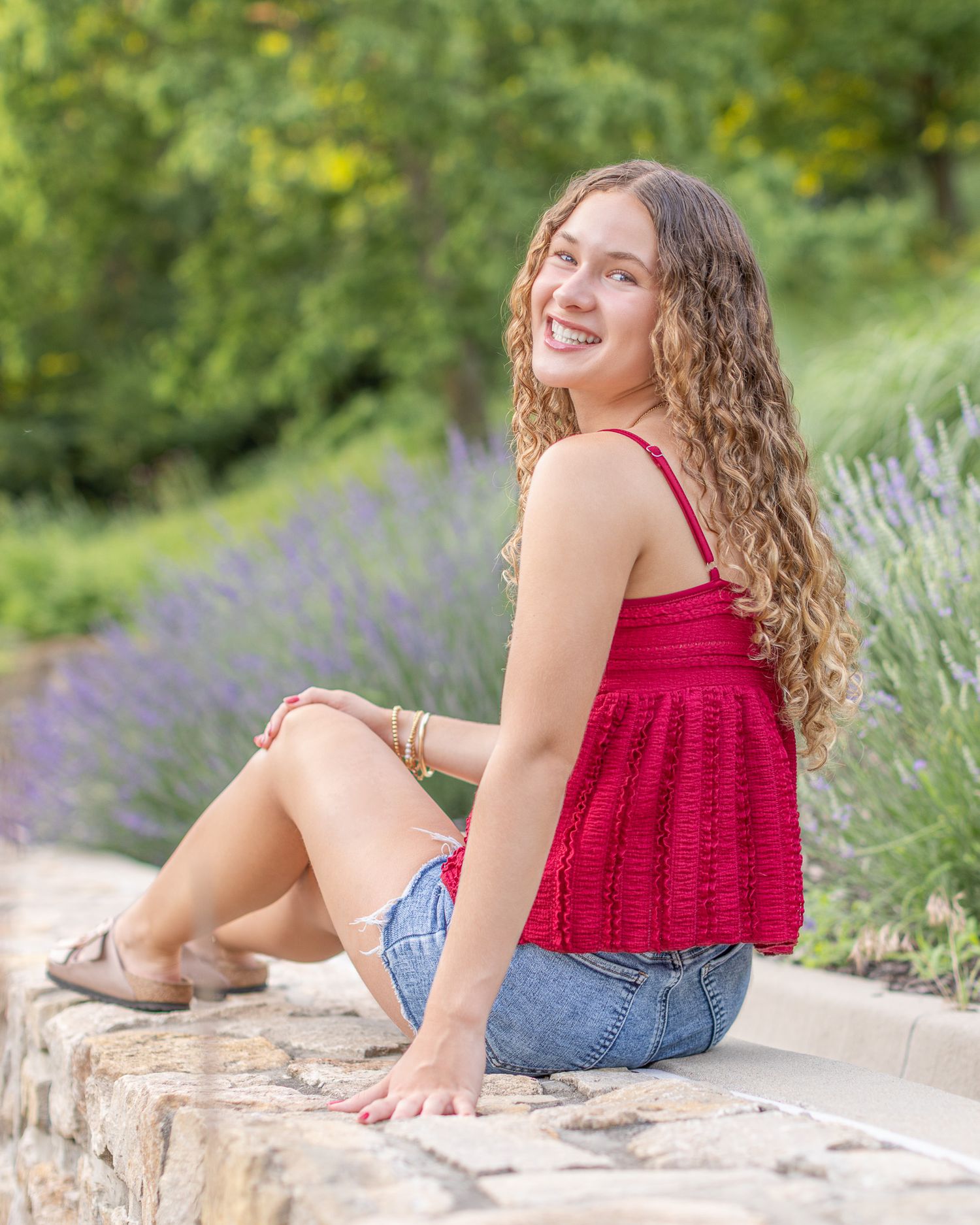 Senior portrait of a young sitting on block wall at Park University in Parkville | Kansas City Northland Portrait Photographer