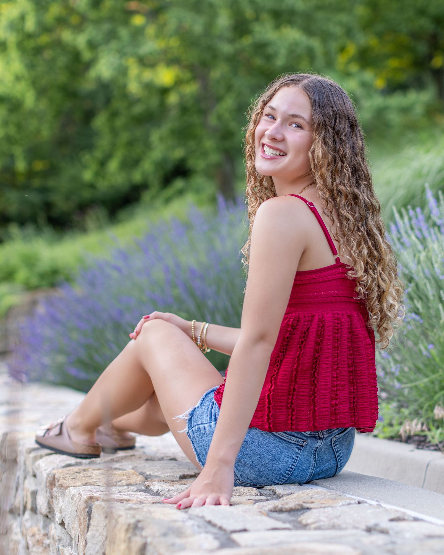 Senior portrait of a young sitting on block wall at Park University in Parkville | Kansas City Northland Portrait Photographer