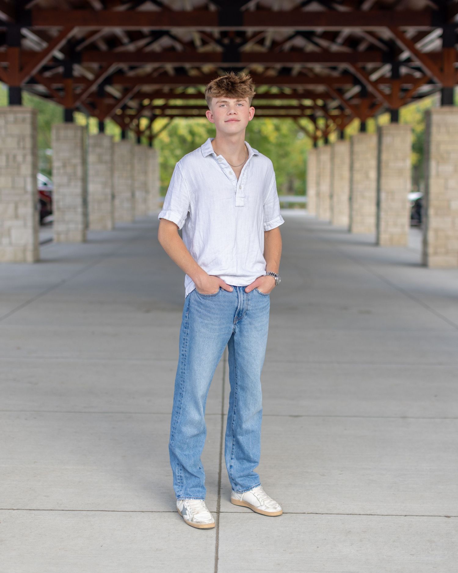 Senior photo of a young man standing at the Farmers Market building in Parkville | Kansas City Northland Portrait Photographer