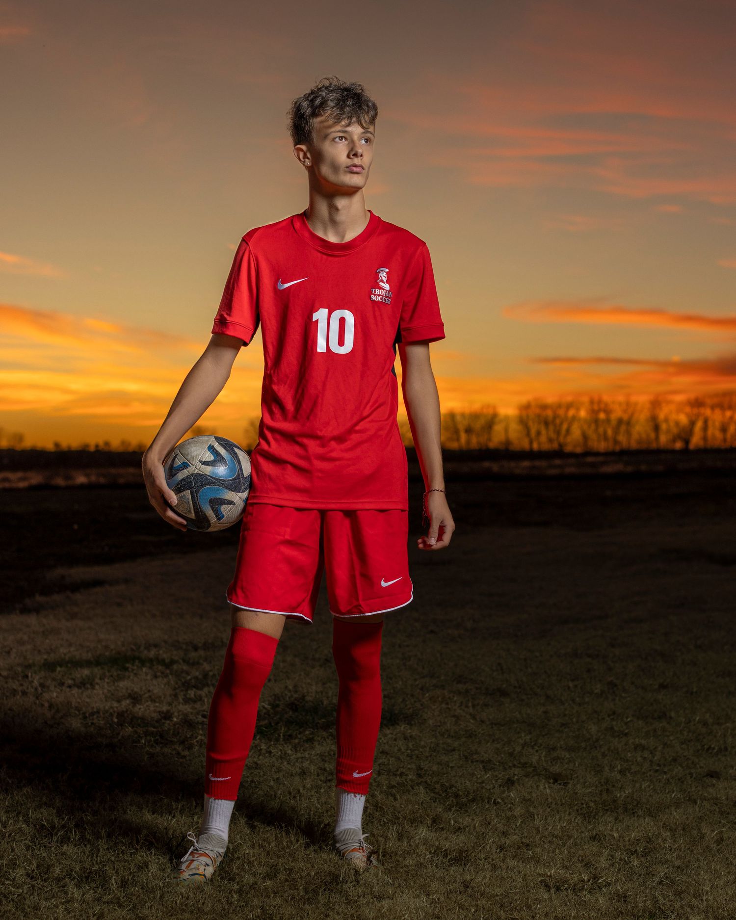 Senior portrait photo of a young man in a soccer uniform at Platte Landing Park in Parkville | Kansas City Northland Portrait Photographer
