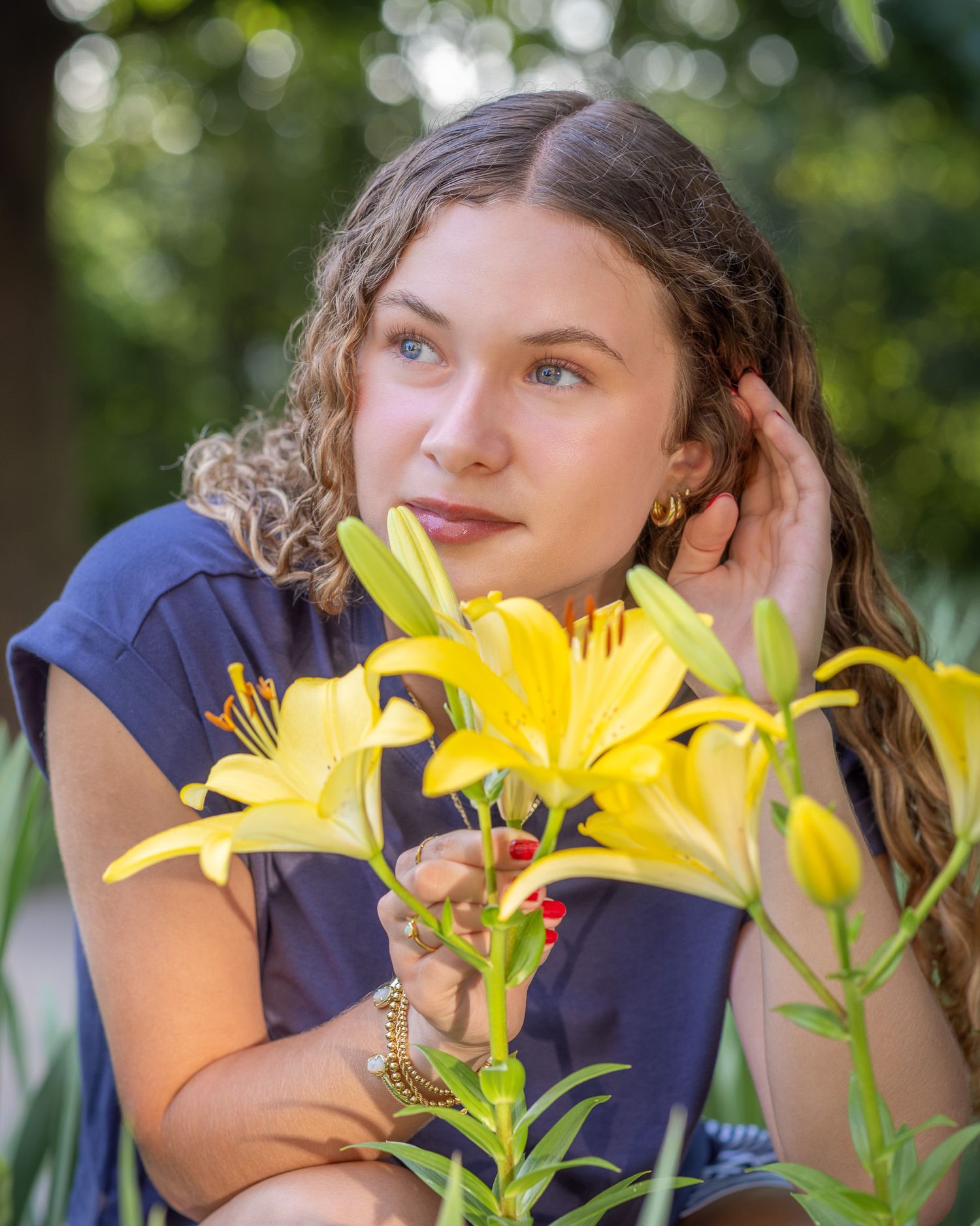 Senior portrait of a young lady admiring flowers at Park University in Parkville | Kansas City Northland Portrait Photographer