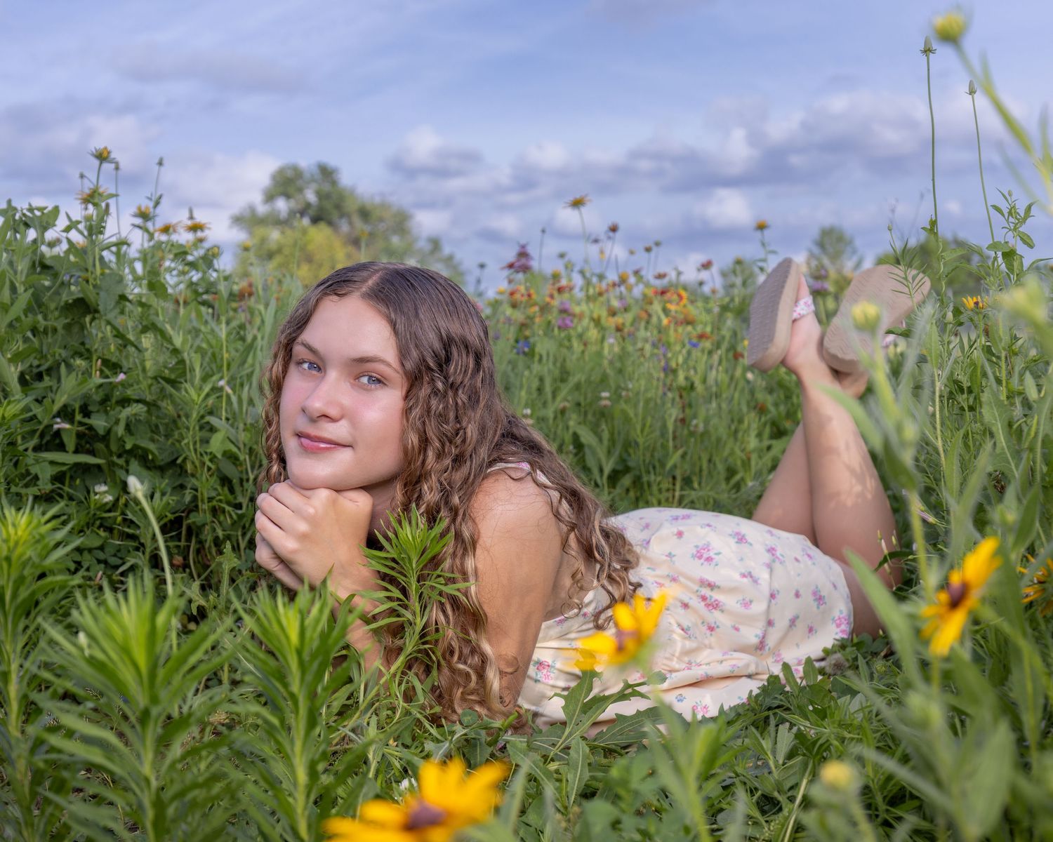 Senior portrait photo of a young lady laying in flowers at English Landing Park in Parkville | Kansas City Northland Portrait Photographer