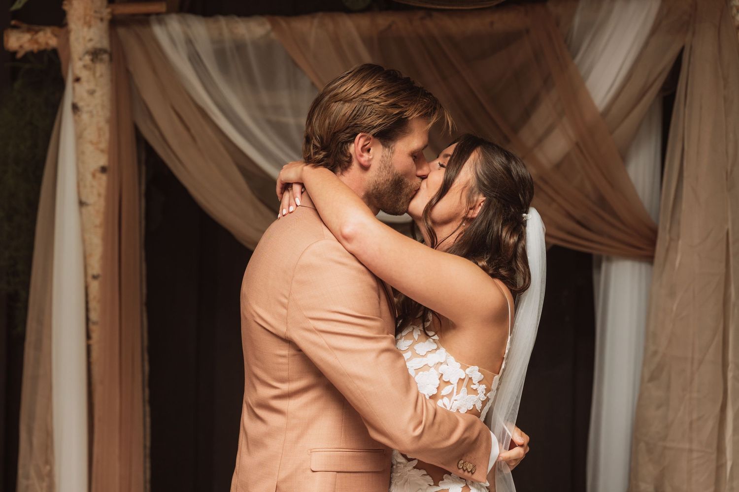 A romantic couple shares intimate moments in a series of wedding photos with soft lighting and elegant decor.