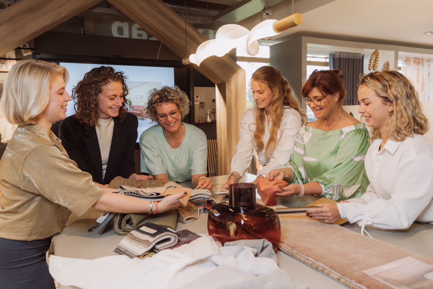 Group of people working together at a table with papers and documents in a collaborative office setting.